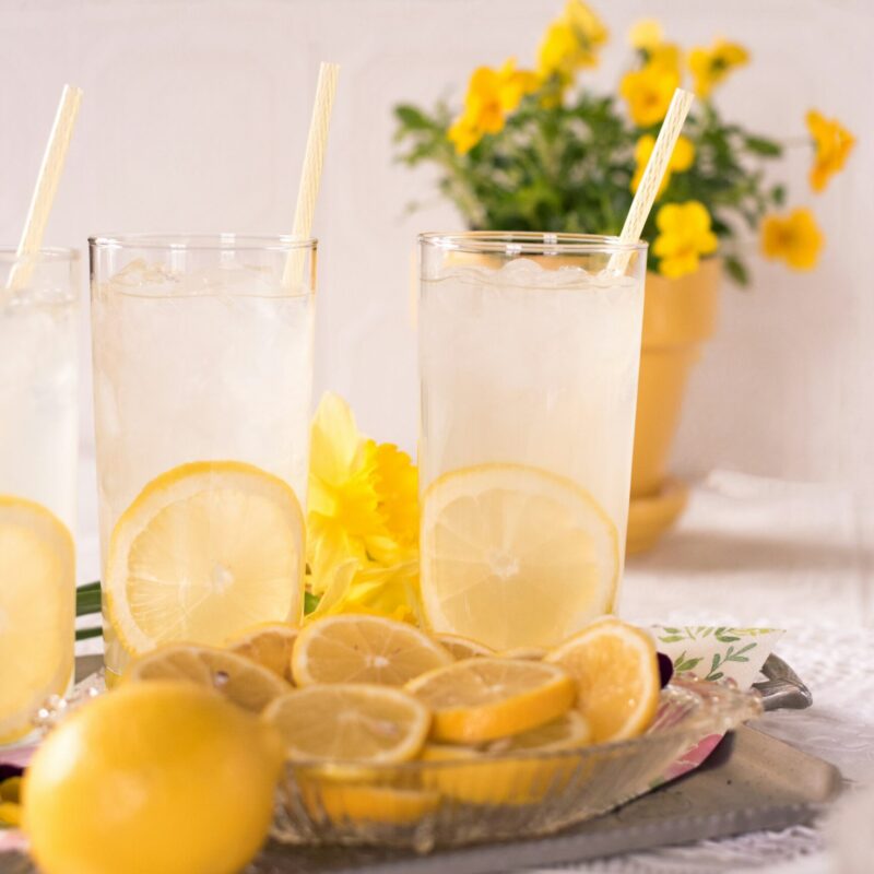 Fette di limone accanto a bicchieri d'acqua trasparenti