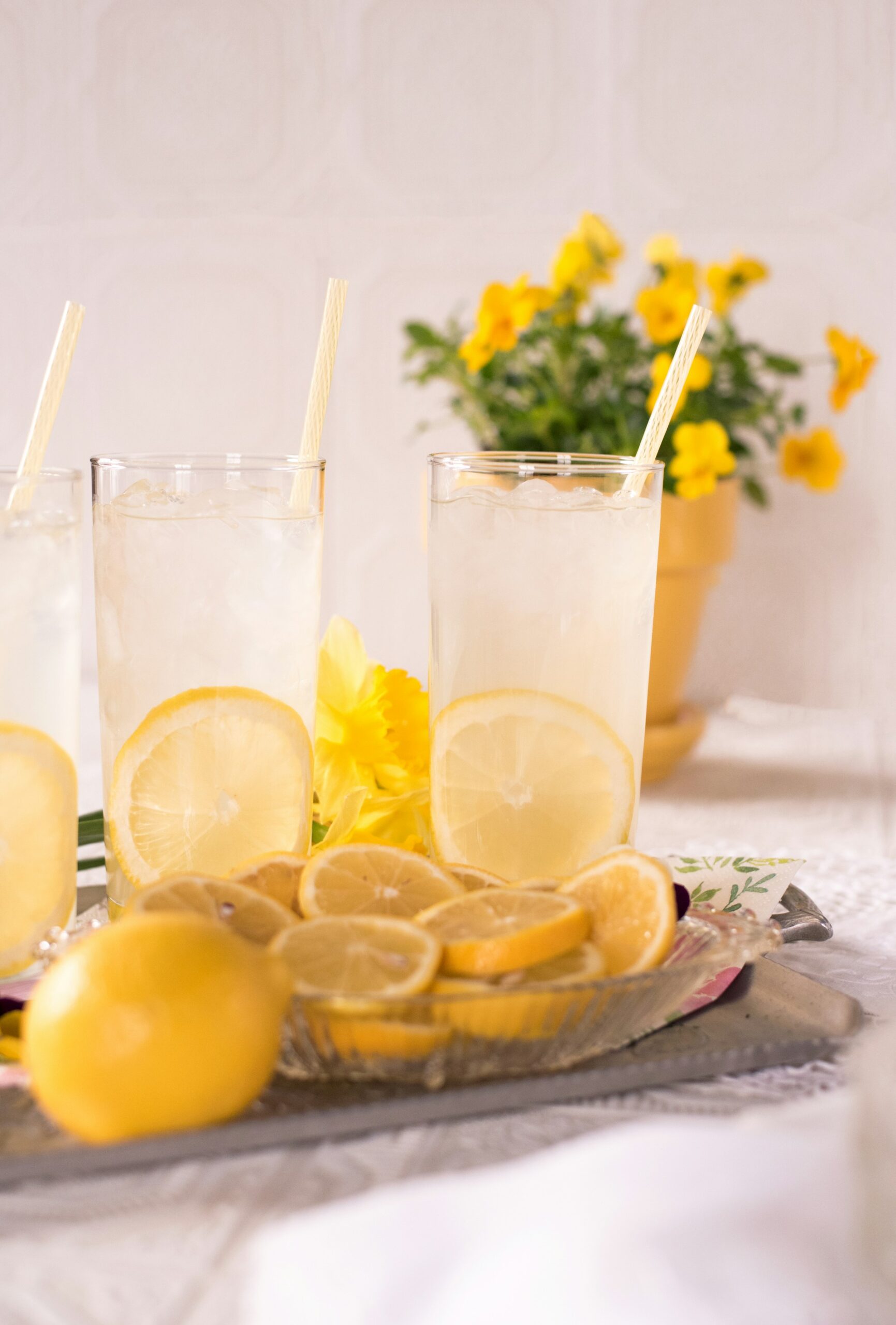 Fette di limone accanto a bicchieri d'acqua trasparenti