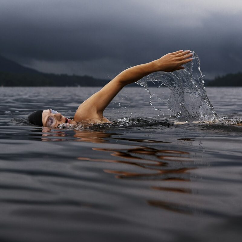 Uomo che nuota in acqua, tema acqua nelle orecchie in estate