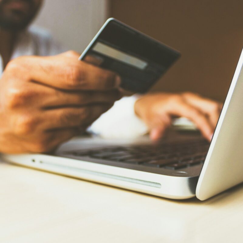 Persona che effettua un pagamento online con carta durante un acquisto