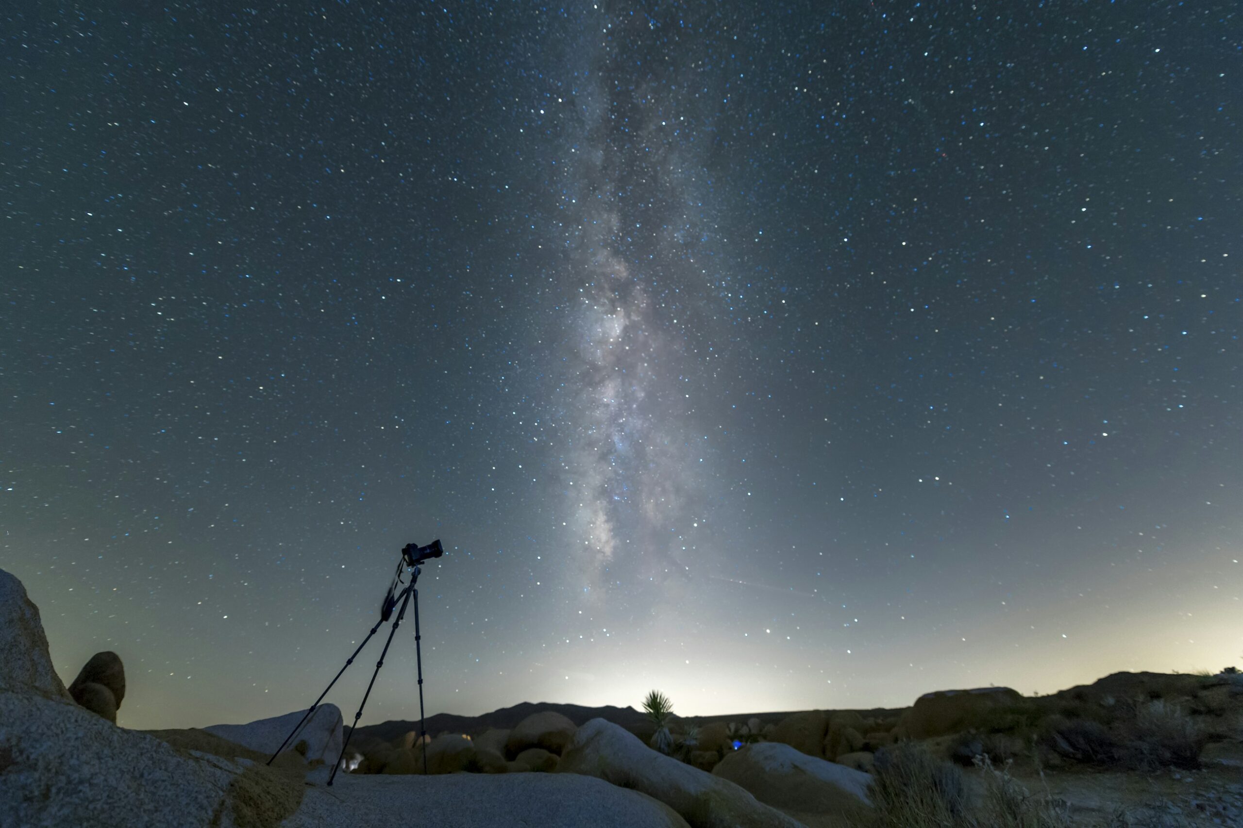 Treppiede con fotocamera per astrofotografia sotto la Via Lattea in una notte invernale
