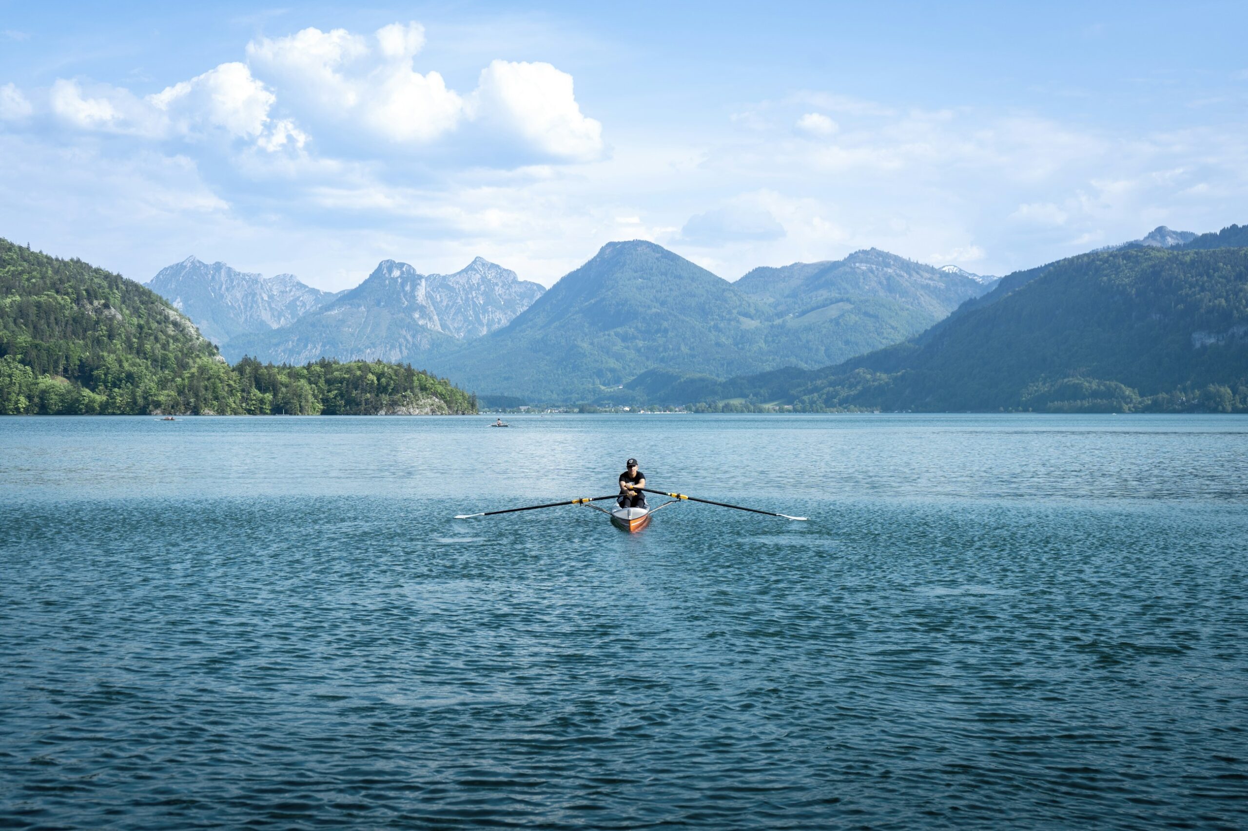 Persona che pratica canottaggio amatoriale su una barca a remi su un lago