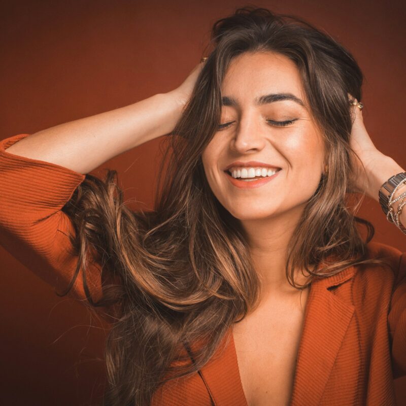 Donna sorridente che si prende cura dei capelli in autunno