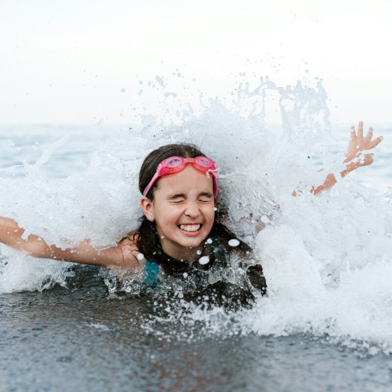 Ragazza che nuota tra le onde del mare durante l'estate
