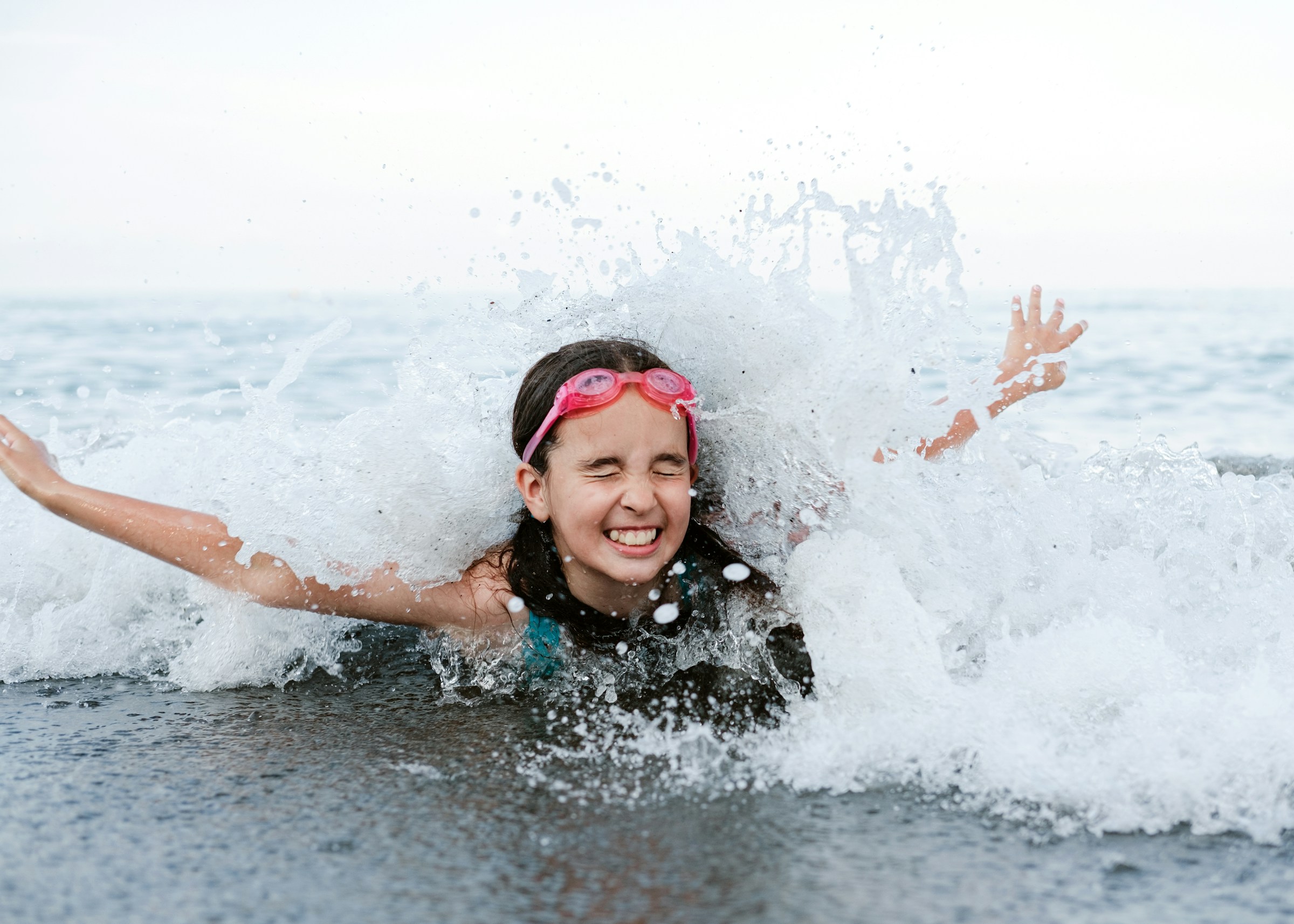 Ragazza che nuota tra le onde del mare durante l'estate