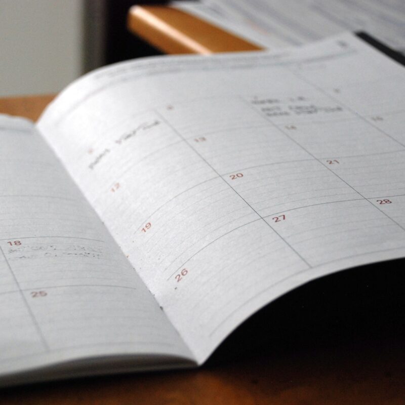 Agenda mensile aperta su una scrivania di legno