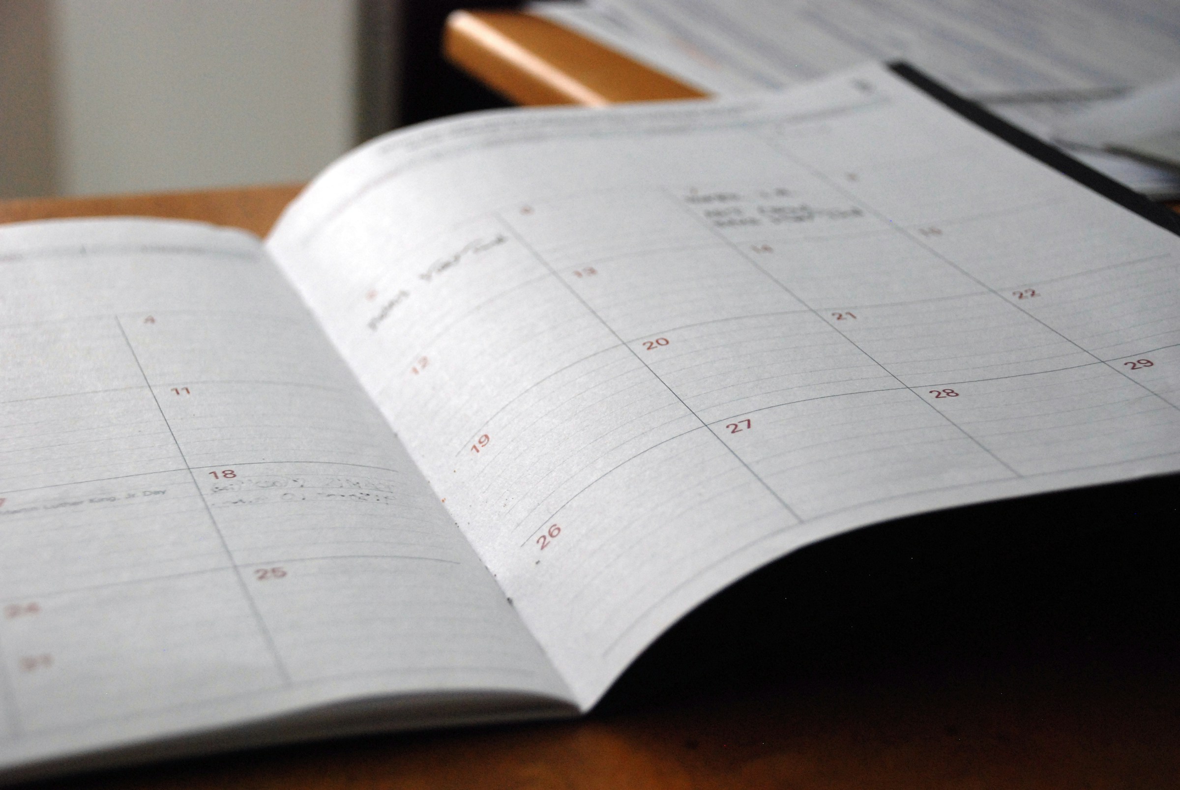 Agenda mensile aperta su una scrivania di legno