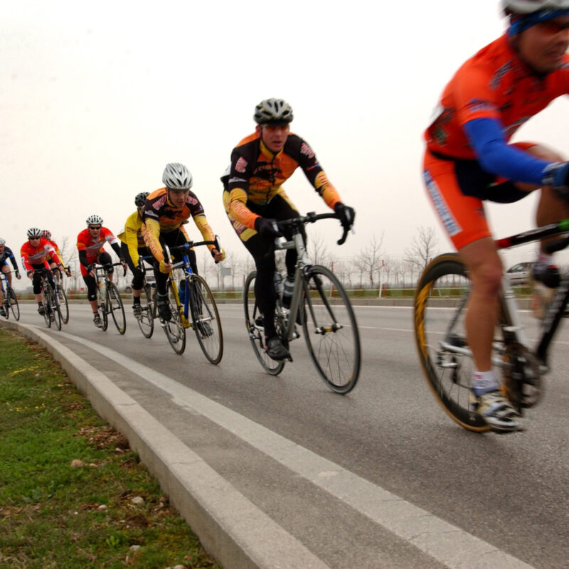 Gruppo di ciclisti in fila su strada