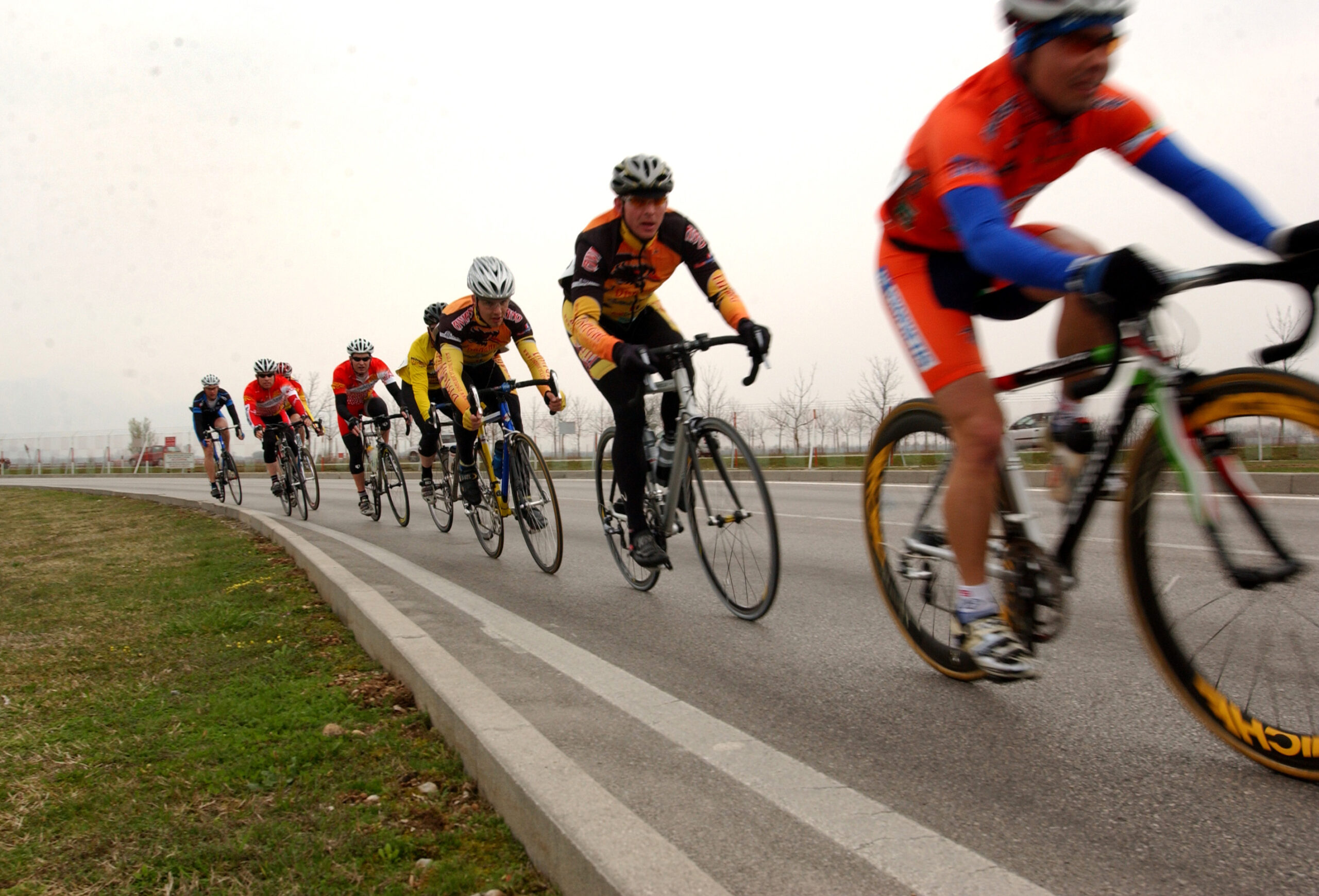 Gruppo di ciclisti in fila su strada
