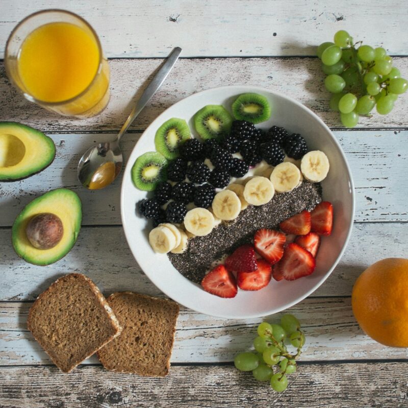 Tavola con colazione sana, frutta fresca e succo d'arancia