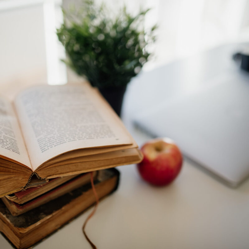 Angolo studio accogliente con quaderno aperto, luce naturale e una mela, simbolo del tornare sui libri da adulti