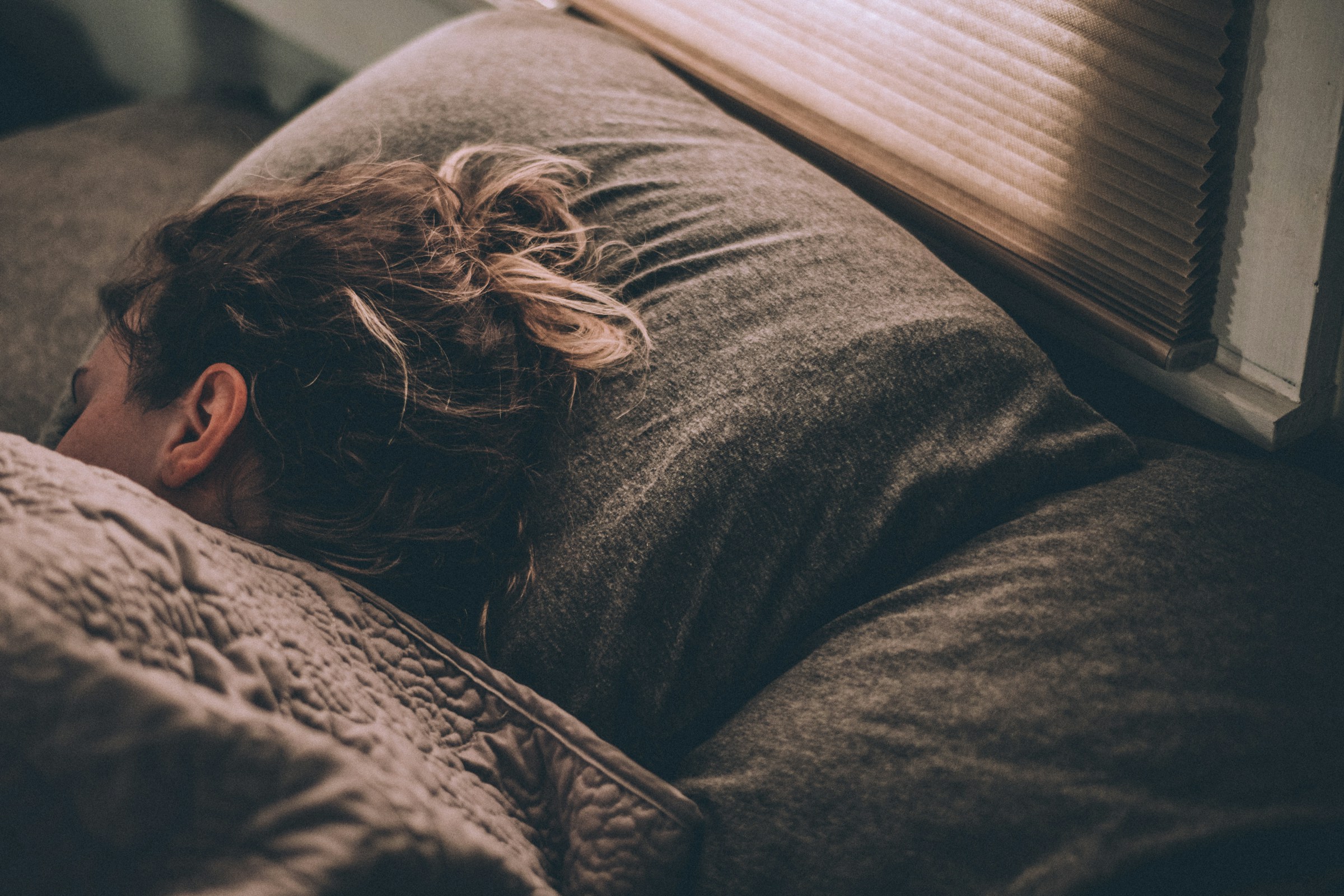 Persona che dorme di notte sotto le coperte