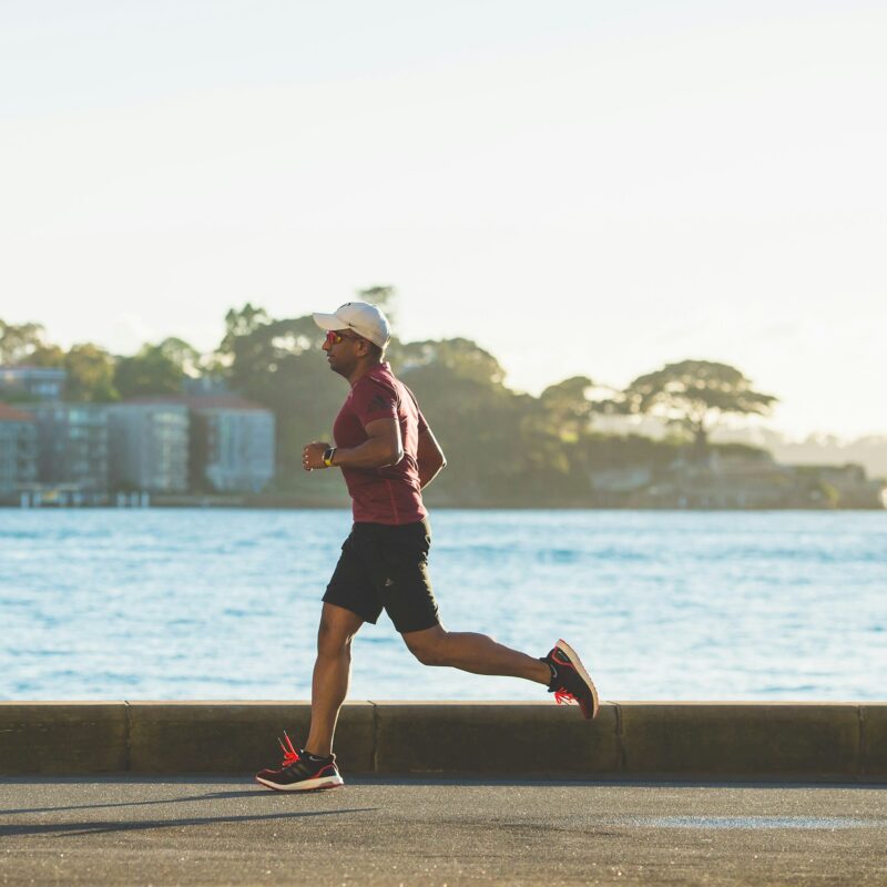 Uomo corre all'aperto lungo il mare al tramonto, running over 40