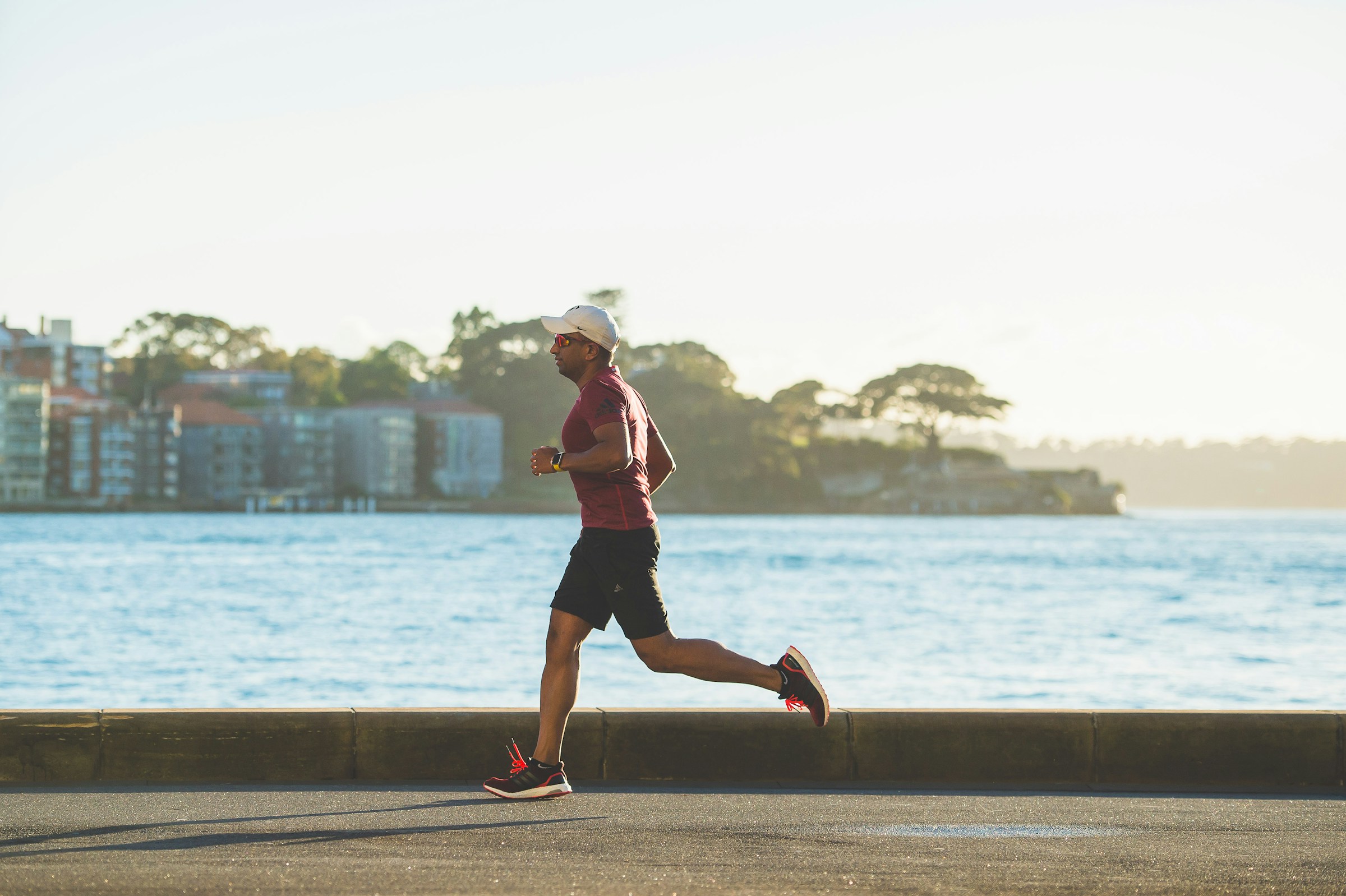 Uomo corre all'aperto lungo il mare al tramonto, running over 40