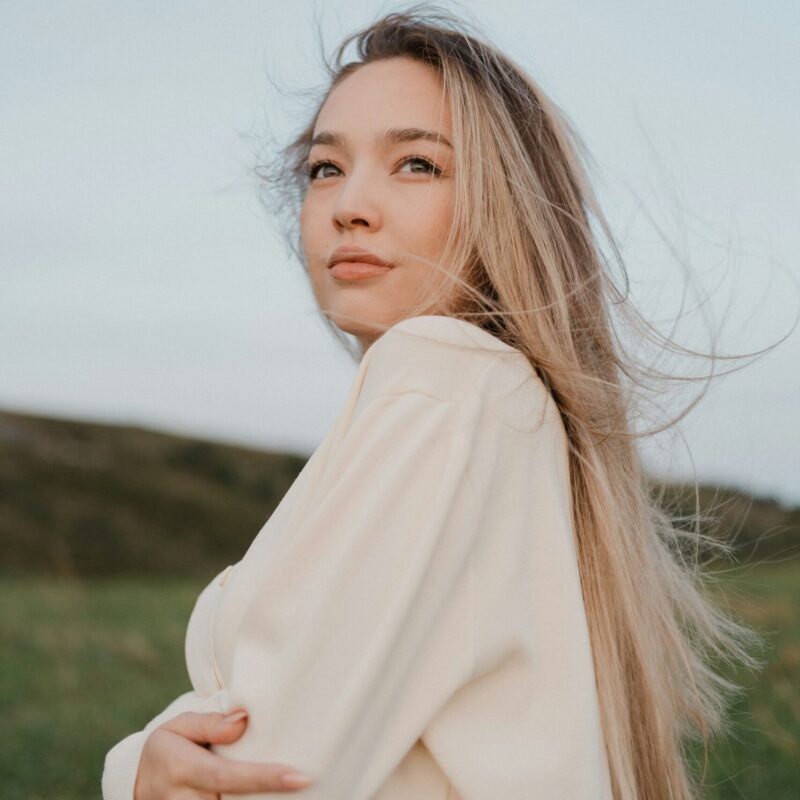 Donna con capelli lunghi mossi dal vento in un campo