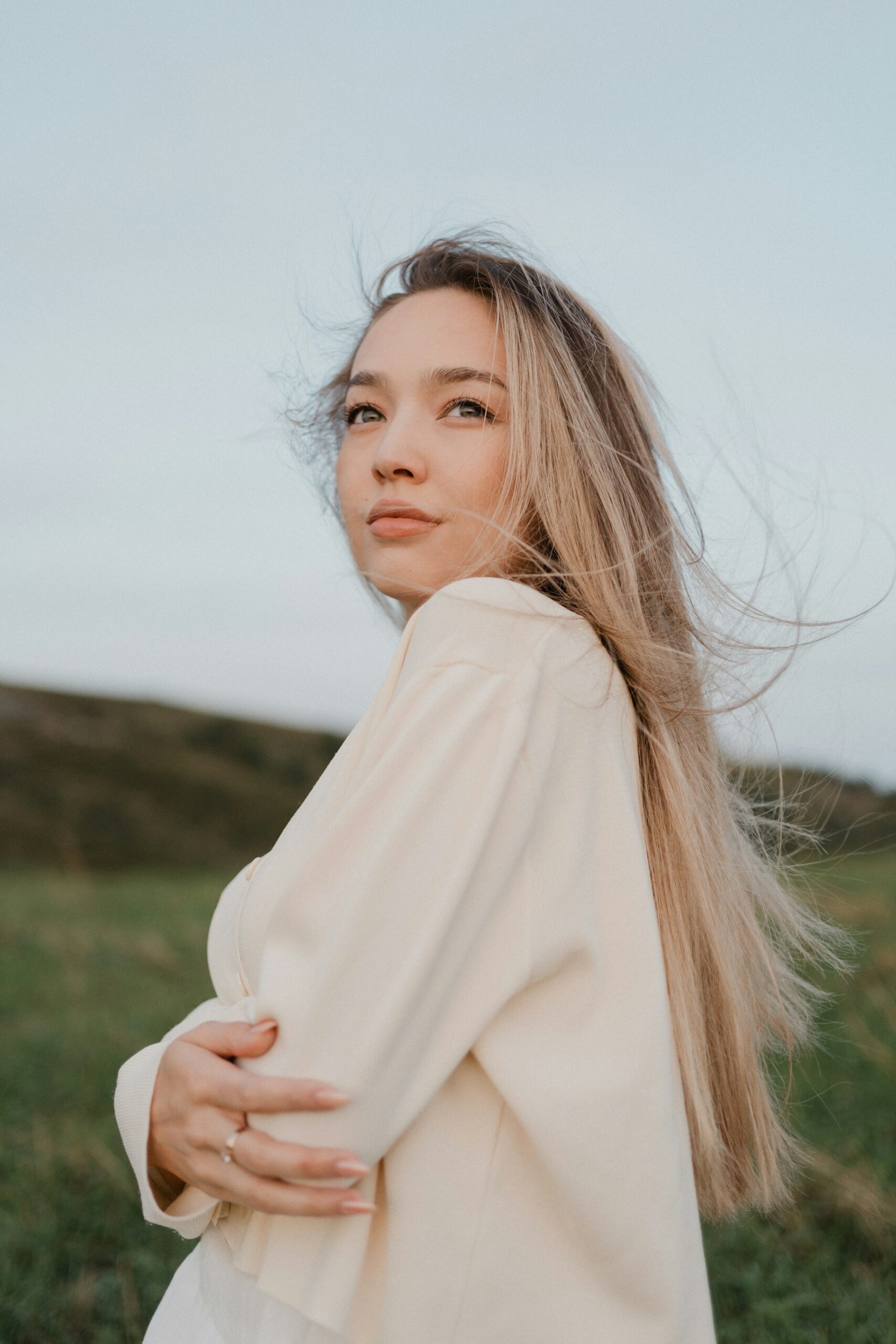Donna con capelli lunghi mossi dal vento in un campo