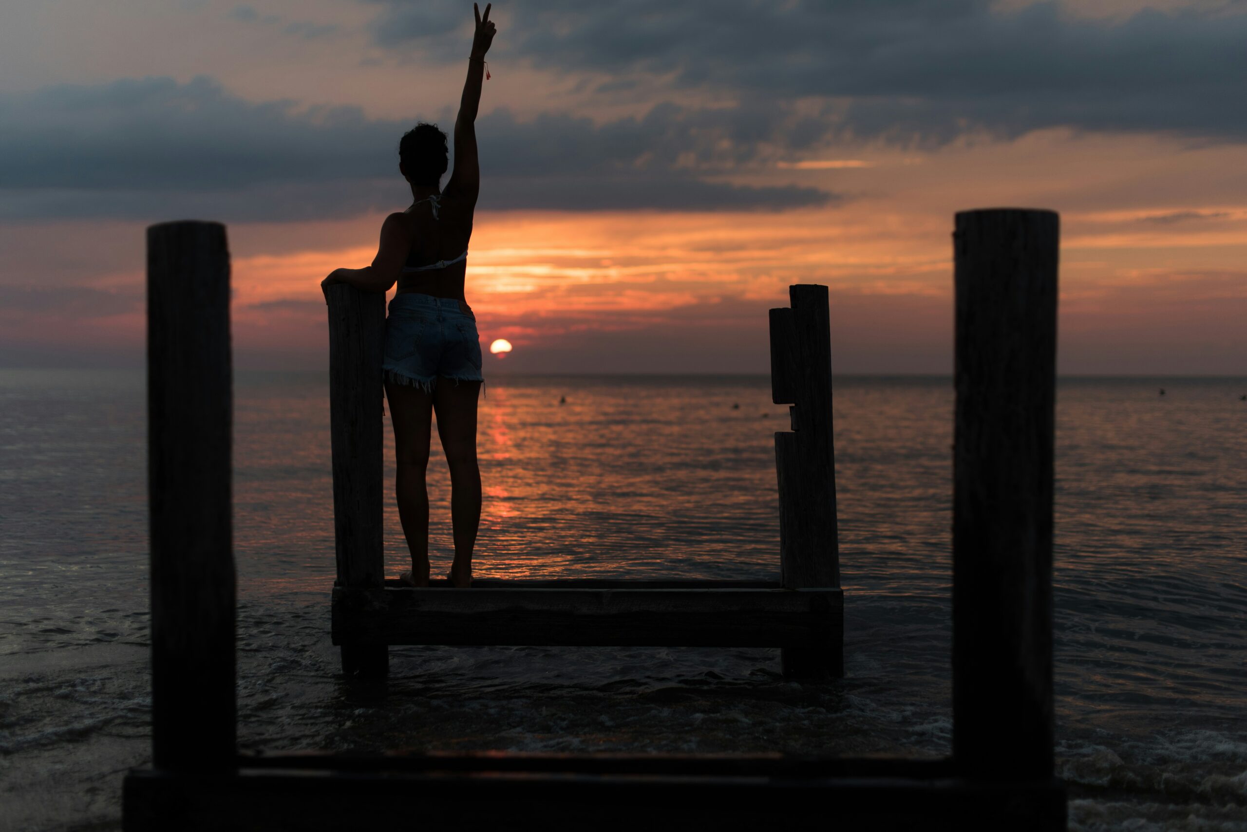 Donna in piedi durante l'alba, braccio alzato, momento di energia mattutina