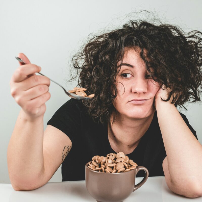 Donna che mangia cereali direttamente dalla ciotola