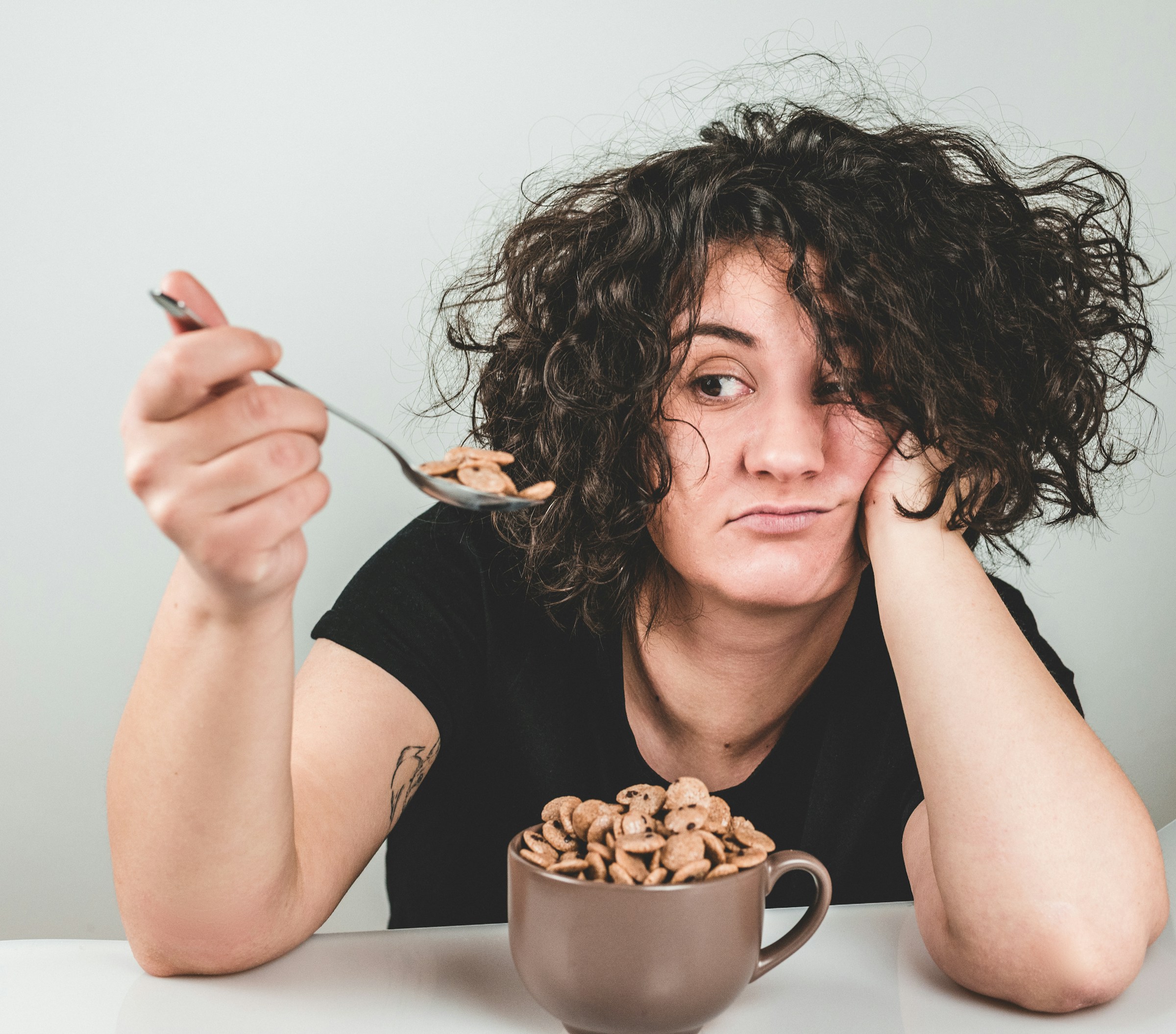 Donna che mangia cereali direttamente dalla ciotola