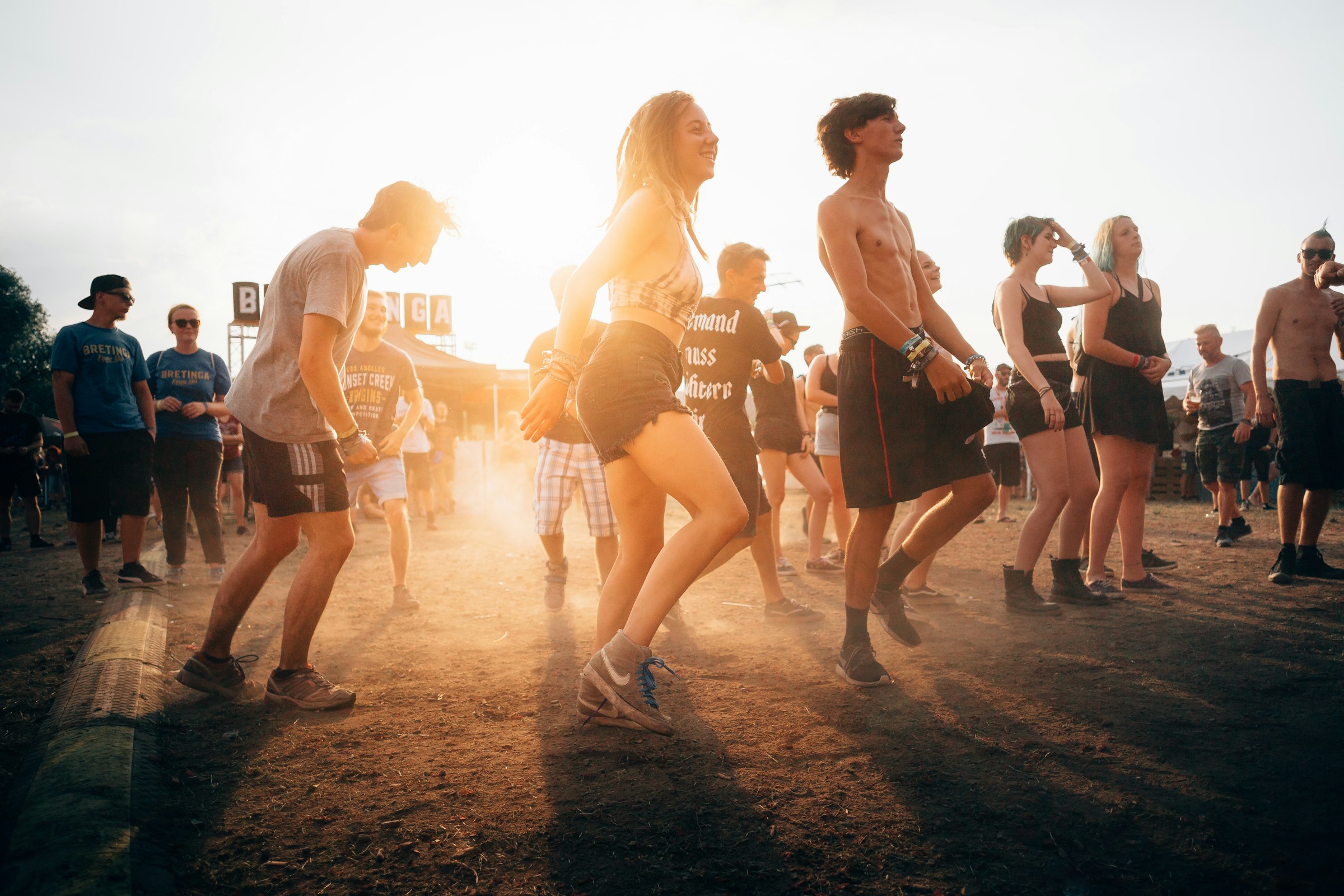 Persone che ballano a un festival musicale estivo al tramonto