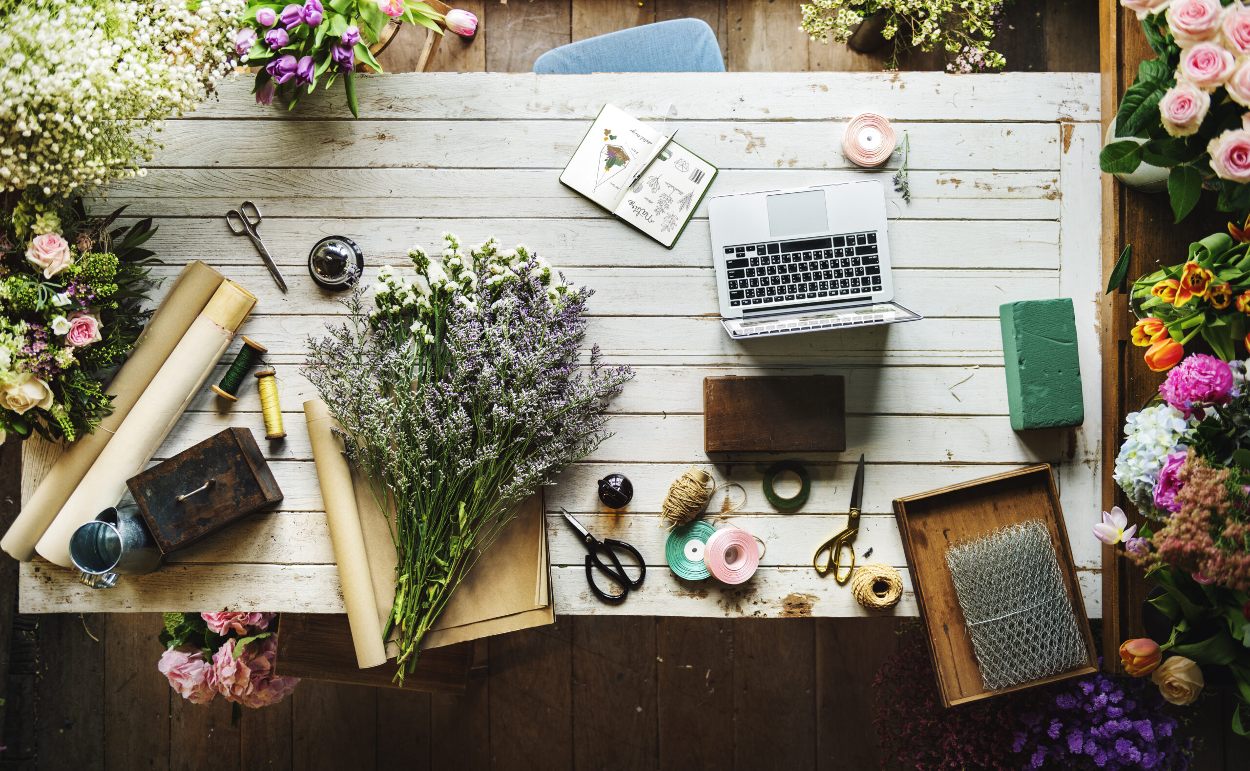 Tavolo da lavoro di un fiorista con fiori recisi e attrezzi