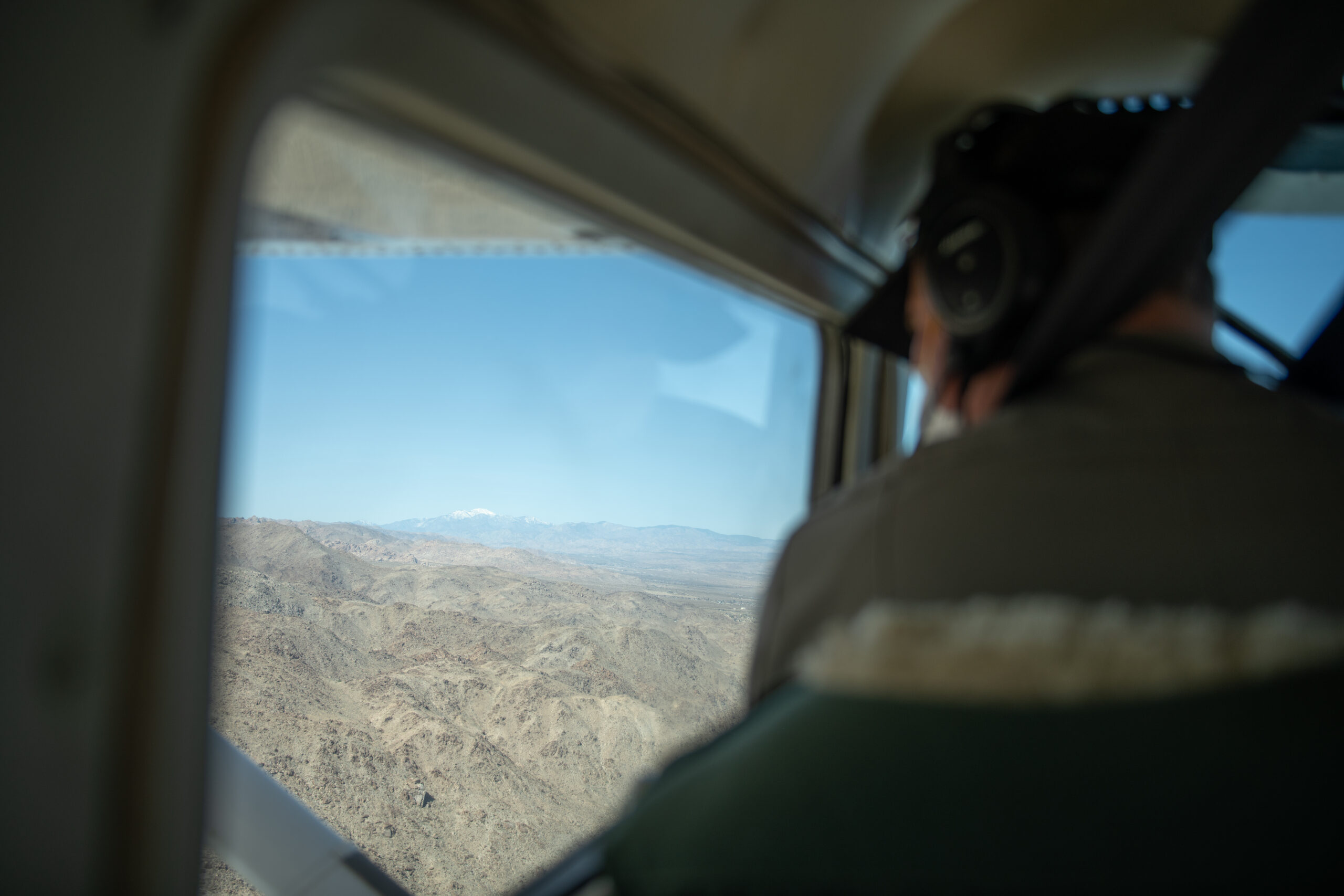 Guardaparco a bordo di un piccolo aereo durante un volo di pattugliamento su un'area naturale protetta