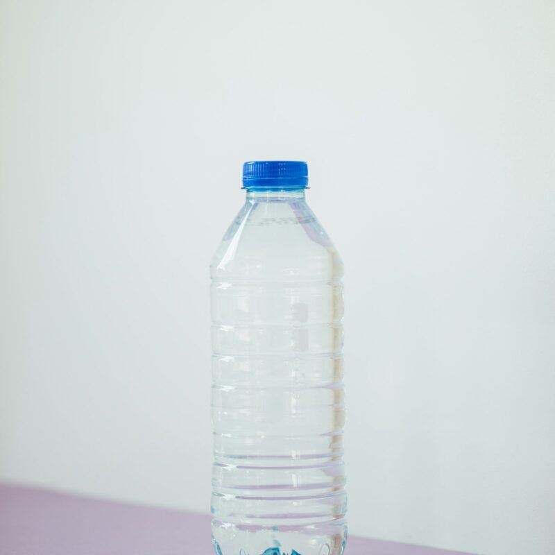 Bottiglia d'acqua trasparente su un tavolo bianco