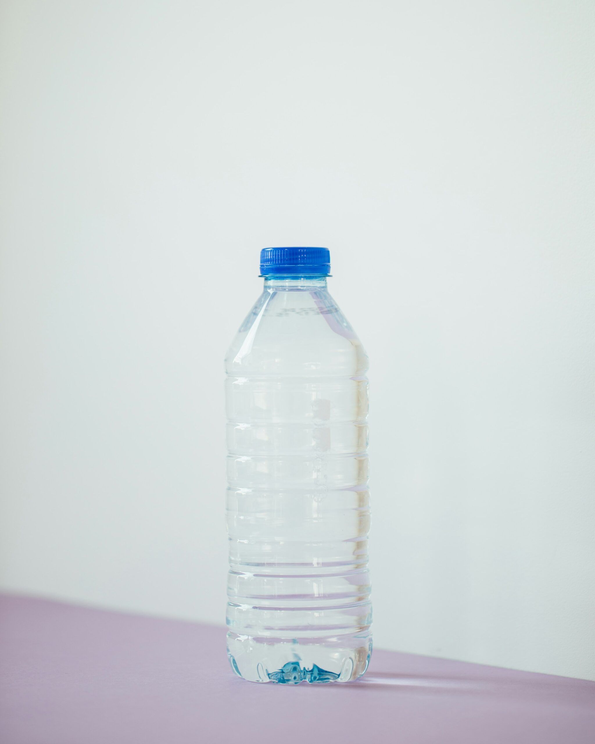 Bottiglia d'acqua trasparente su un tavolo bianco