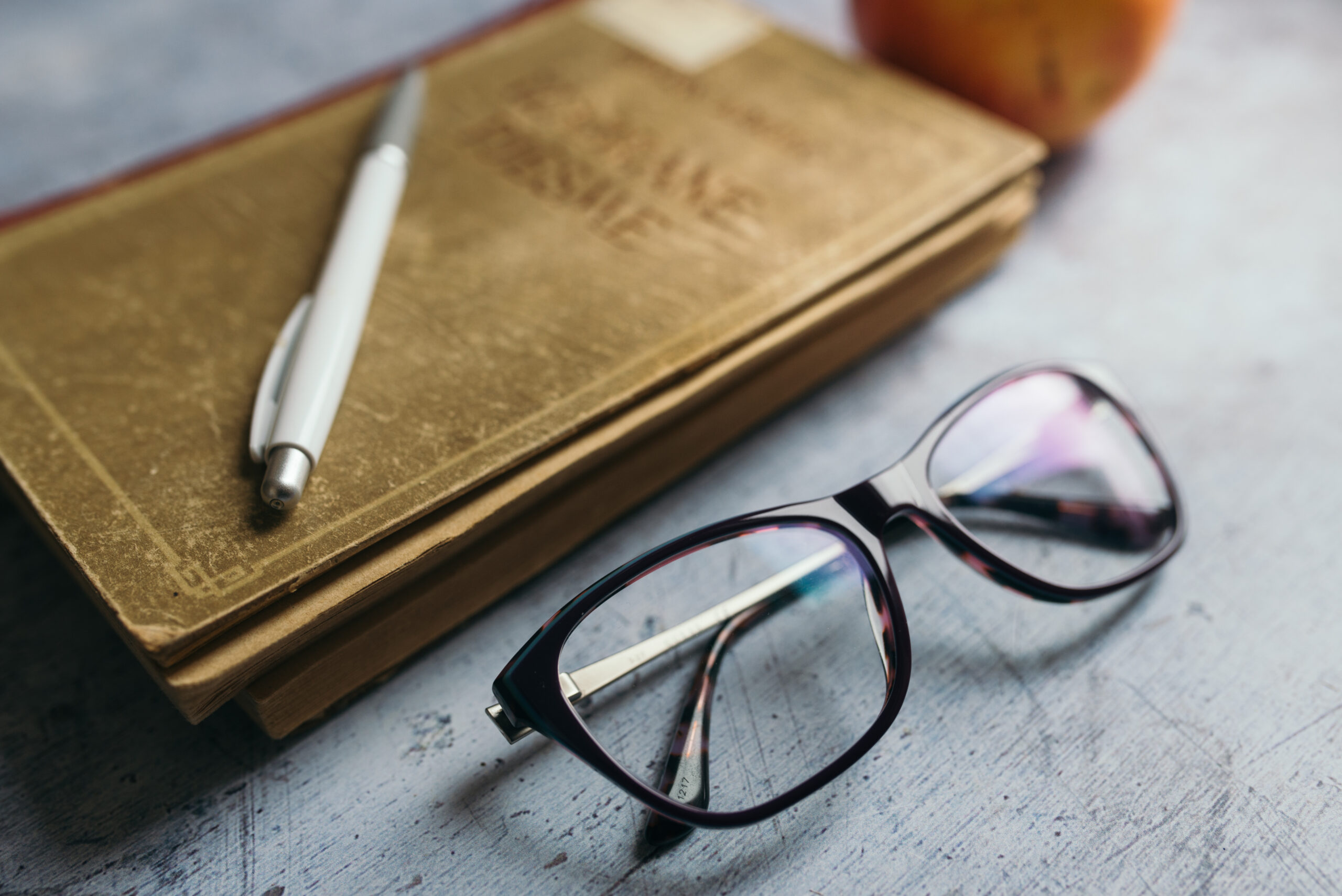 Occhiali, penna e libri su una scrivania