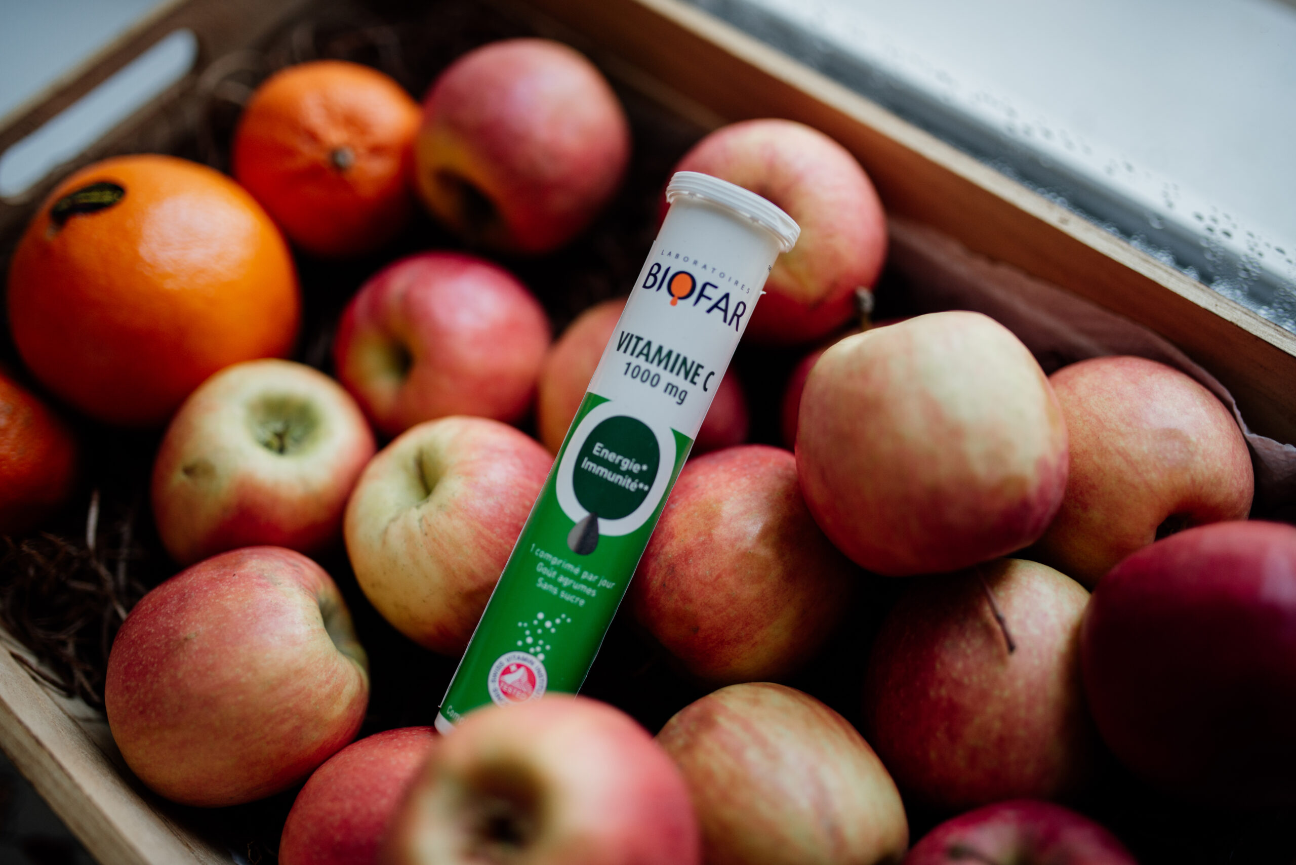 Frutta fresca e integratore di vitamina C su un tavolo di legno