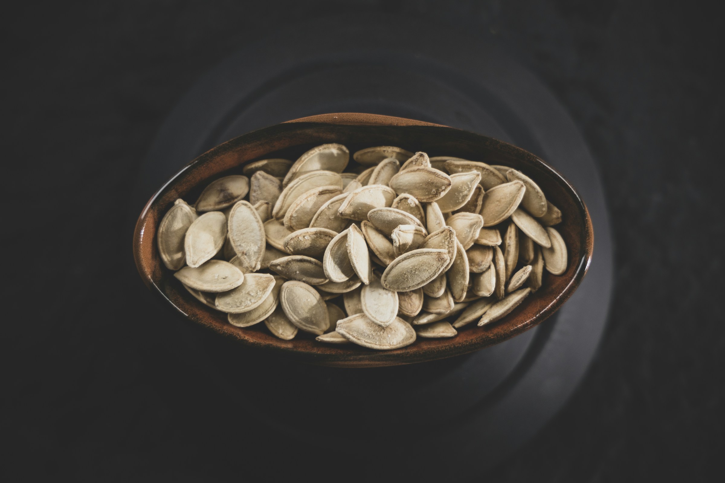 Semi di zucca in ciotola, fonte alimentare di magnesio