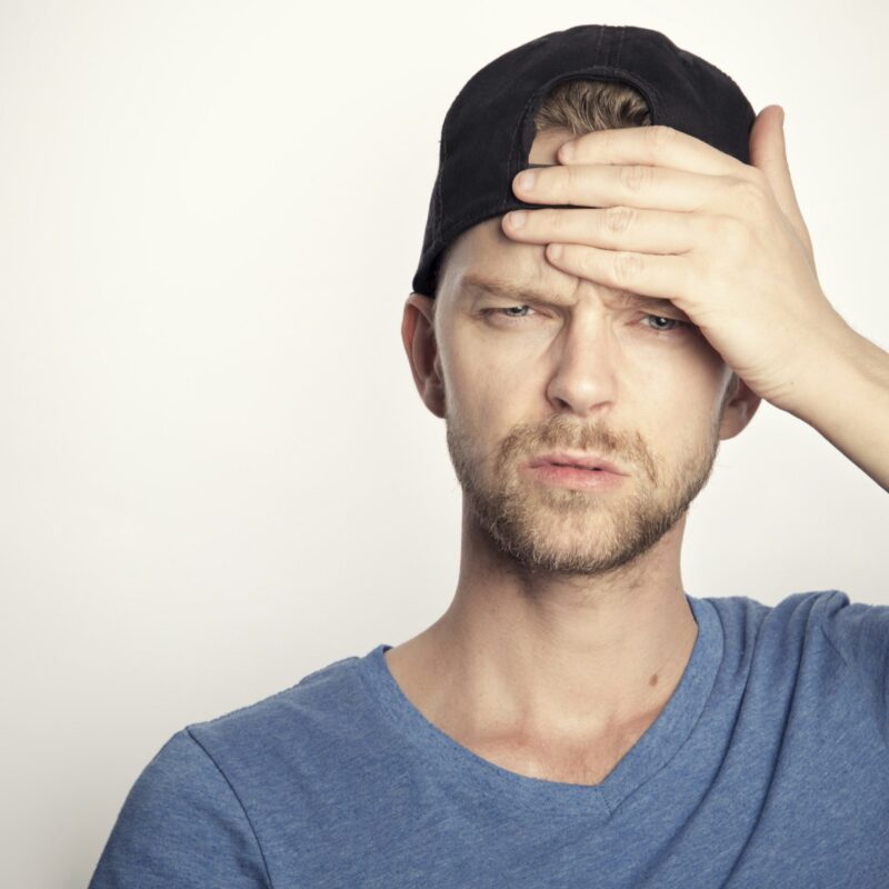 Uomo che si copre il viso per il mal di testa provocato dal caldo intenso