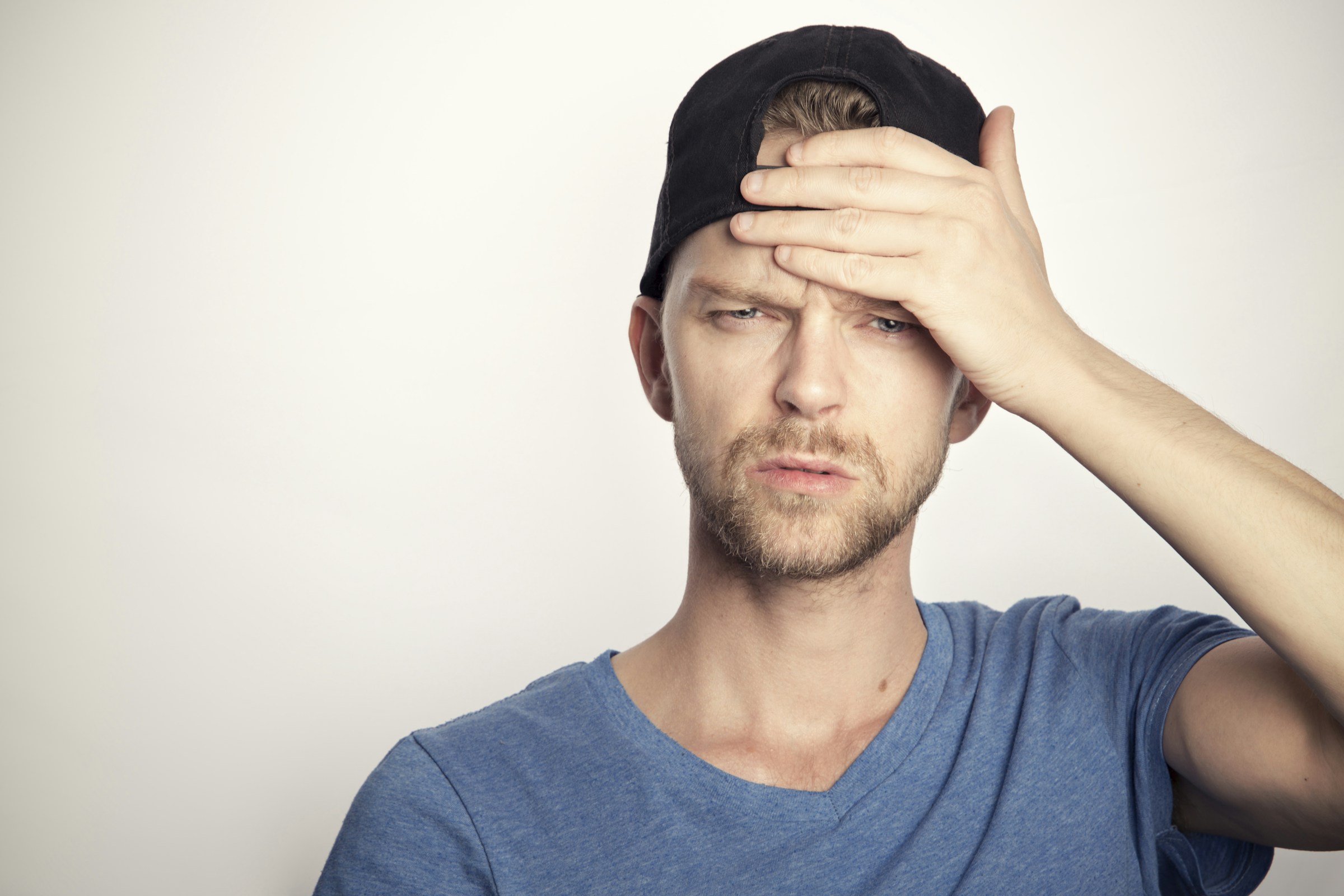Uomo che si copre il viso per il mal di testa provocato dal caldo intenso