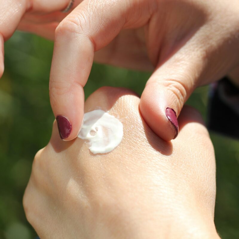 Crema idratante applicata sul dorso della mano, cura delle mani screpolate in inverno