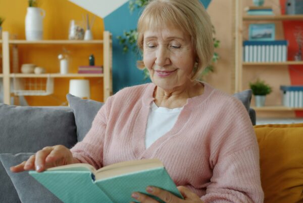 Donna anziana concentrata nella lettura di un libro, momento di attività mentale