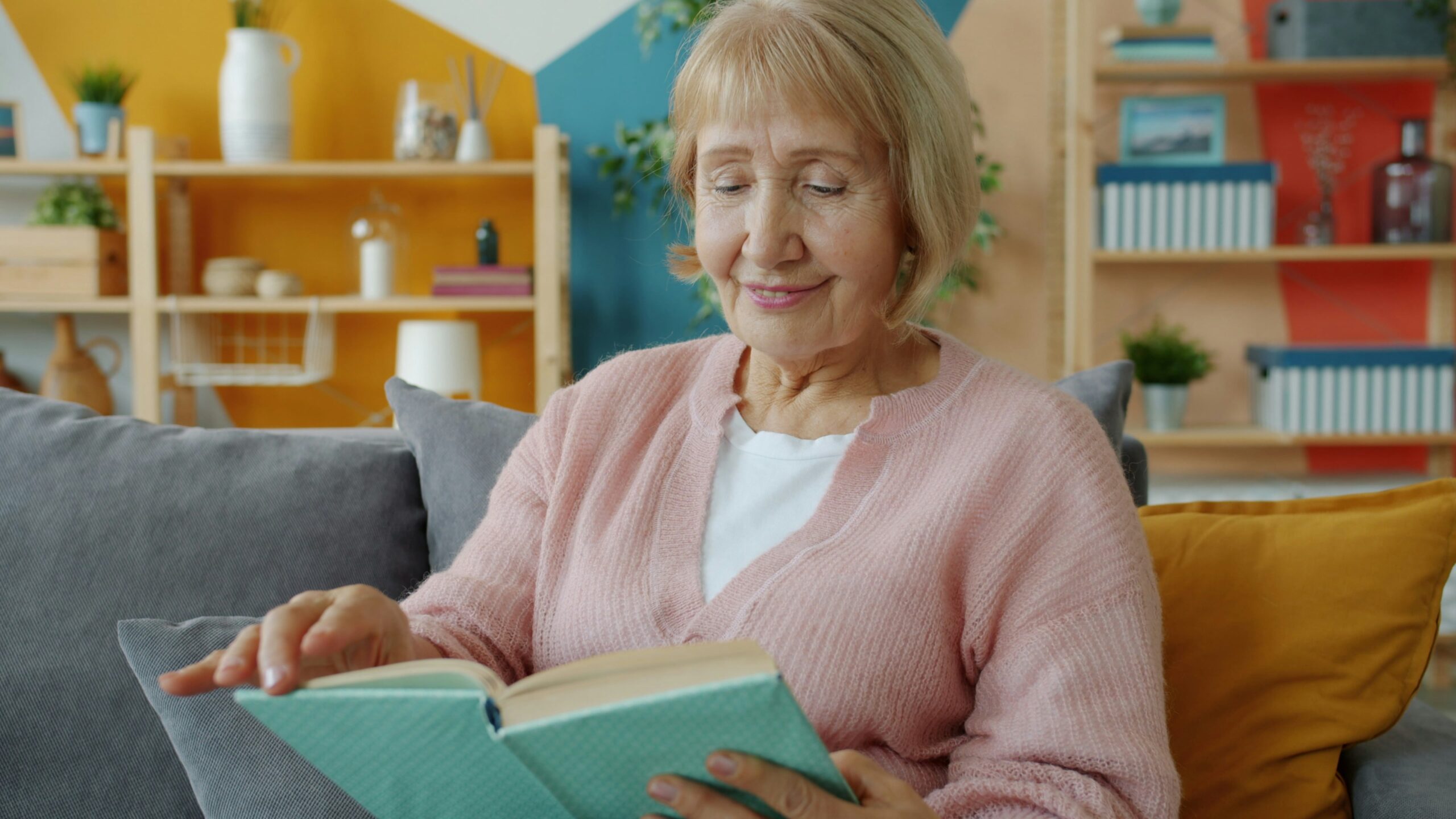 Donna anziana concentrata nella lettura di un libro, momento di attività mentale