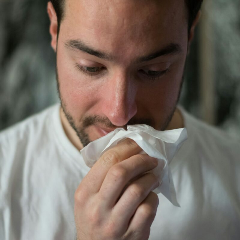 Uomo che si soffia il naso con un fazzoletto