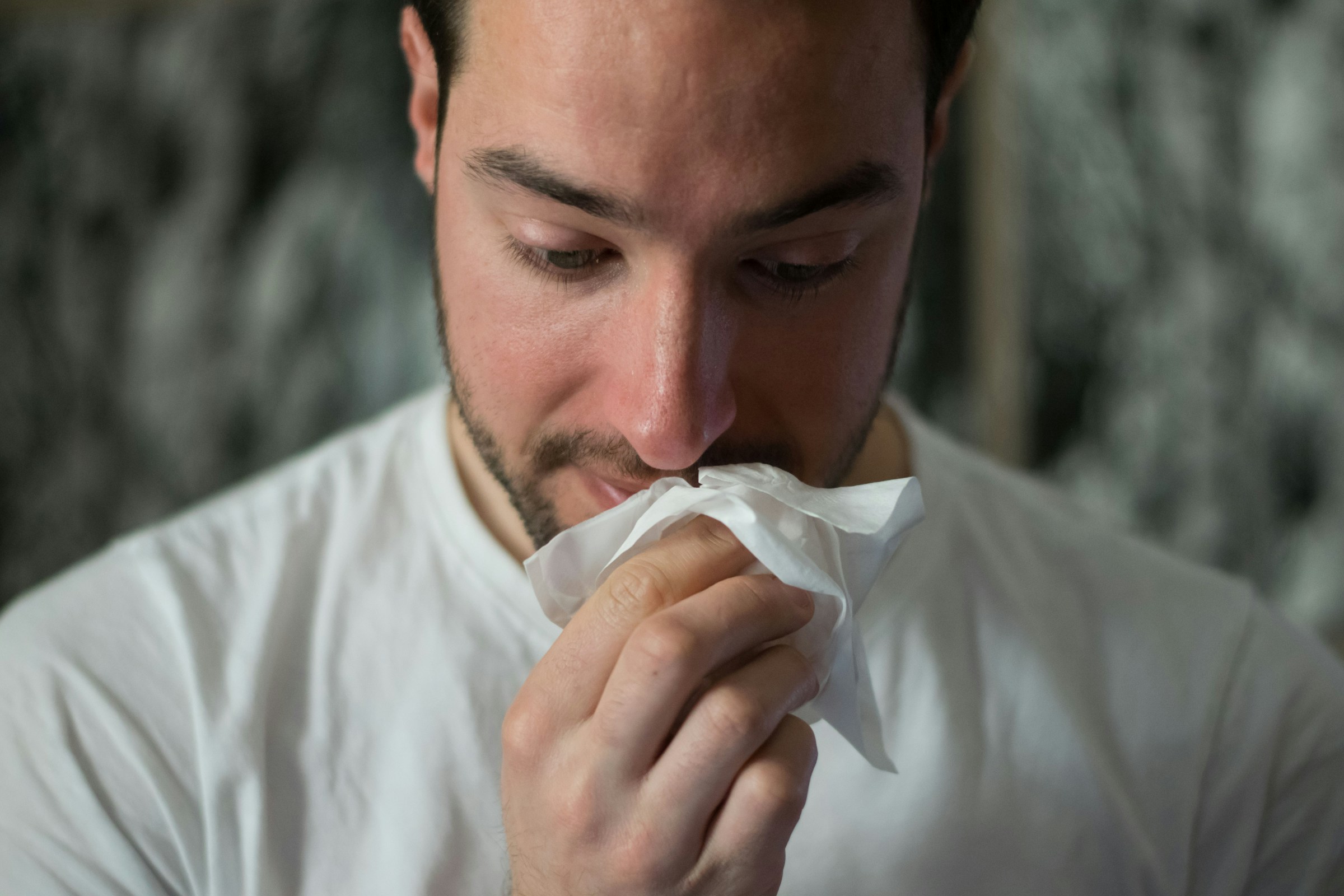 Uomo che si soffia il naso con un fazzoletto
