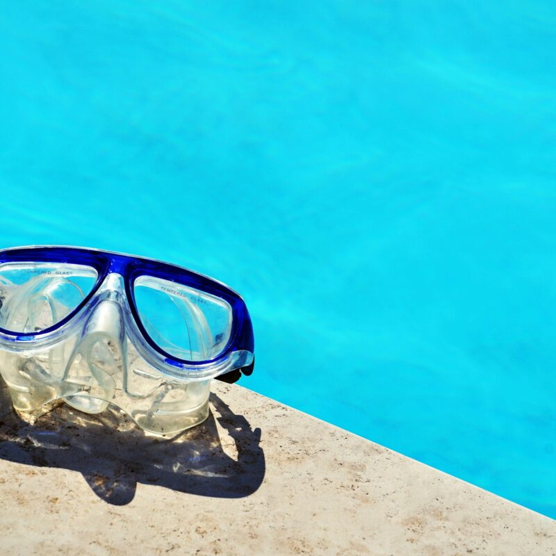 Occhialini da nuoto vicino a una piscina