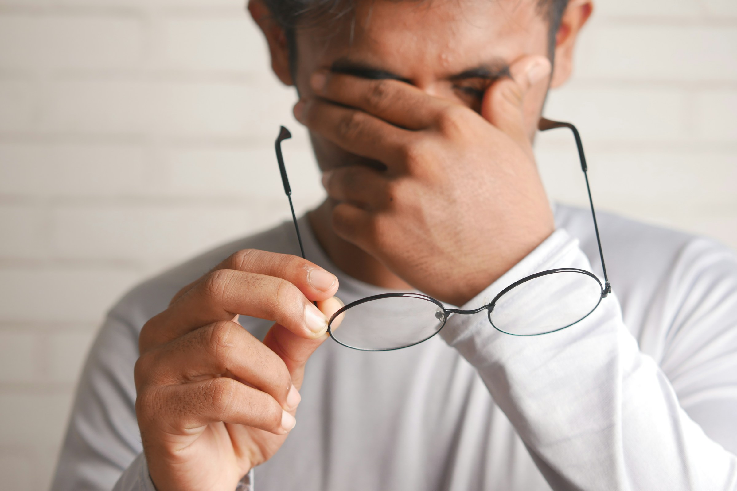 Uomo che si toglie gli occhiali per occhi affaticati in inverno