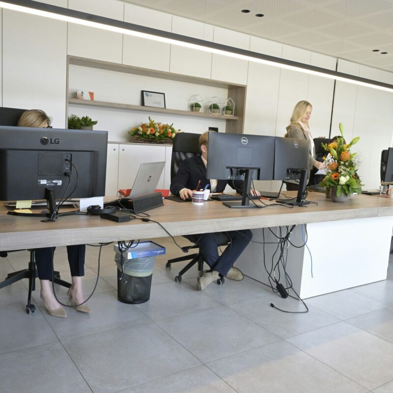 Persone al lavoro davanti a schermi in un ufficio open space dopo il rientro