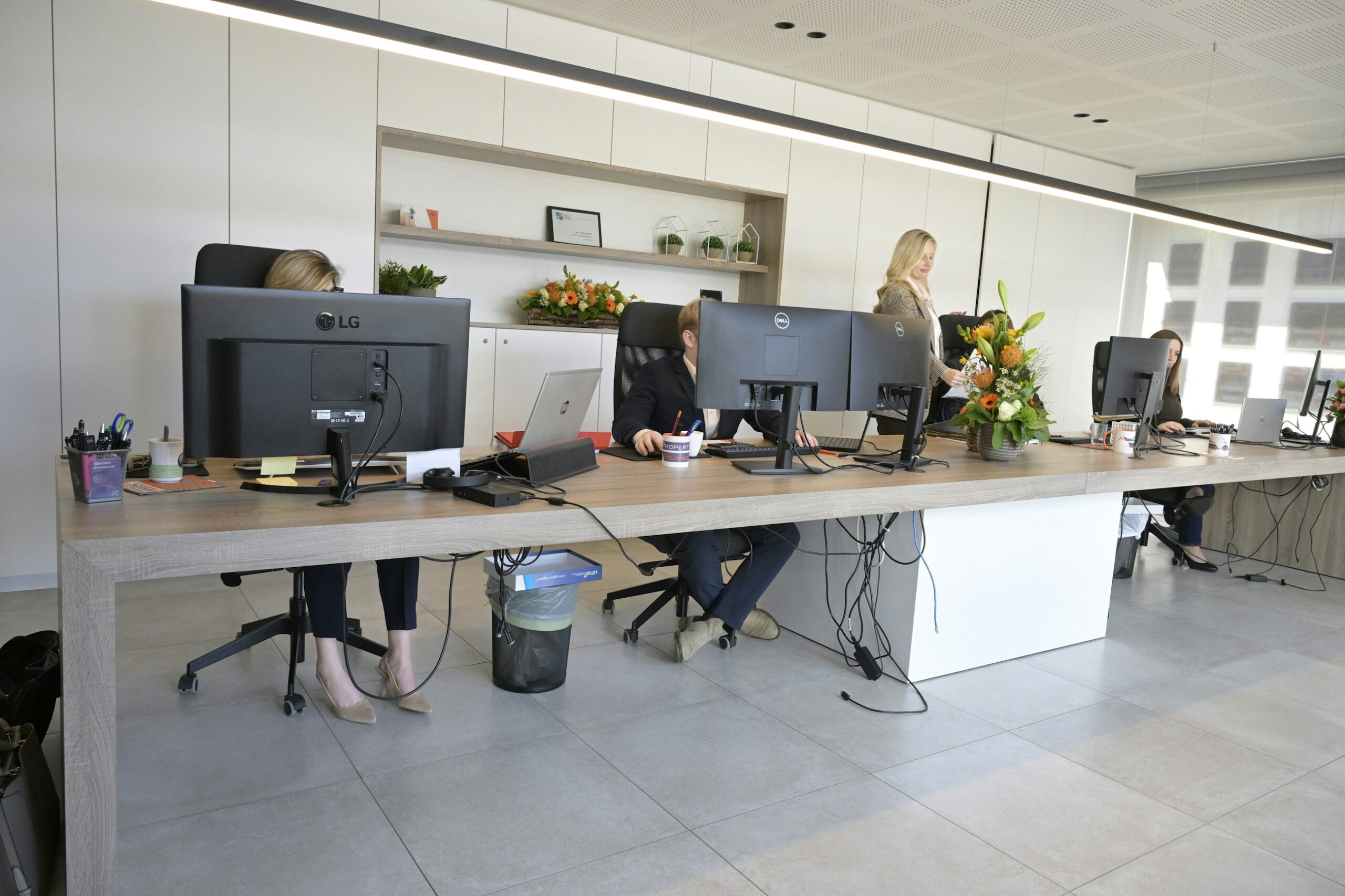 Persone al lavoro davanti a schermi in un ufficio open space dopo il rientro