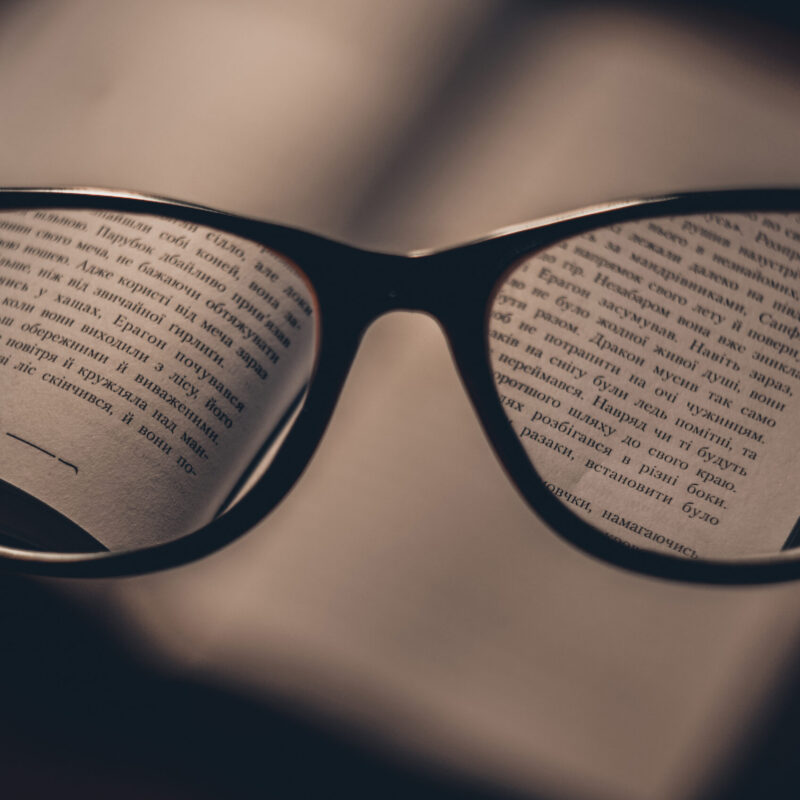 Occhiali da lettura appoggiati su un libro aperto