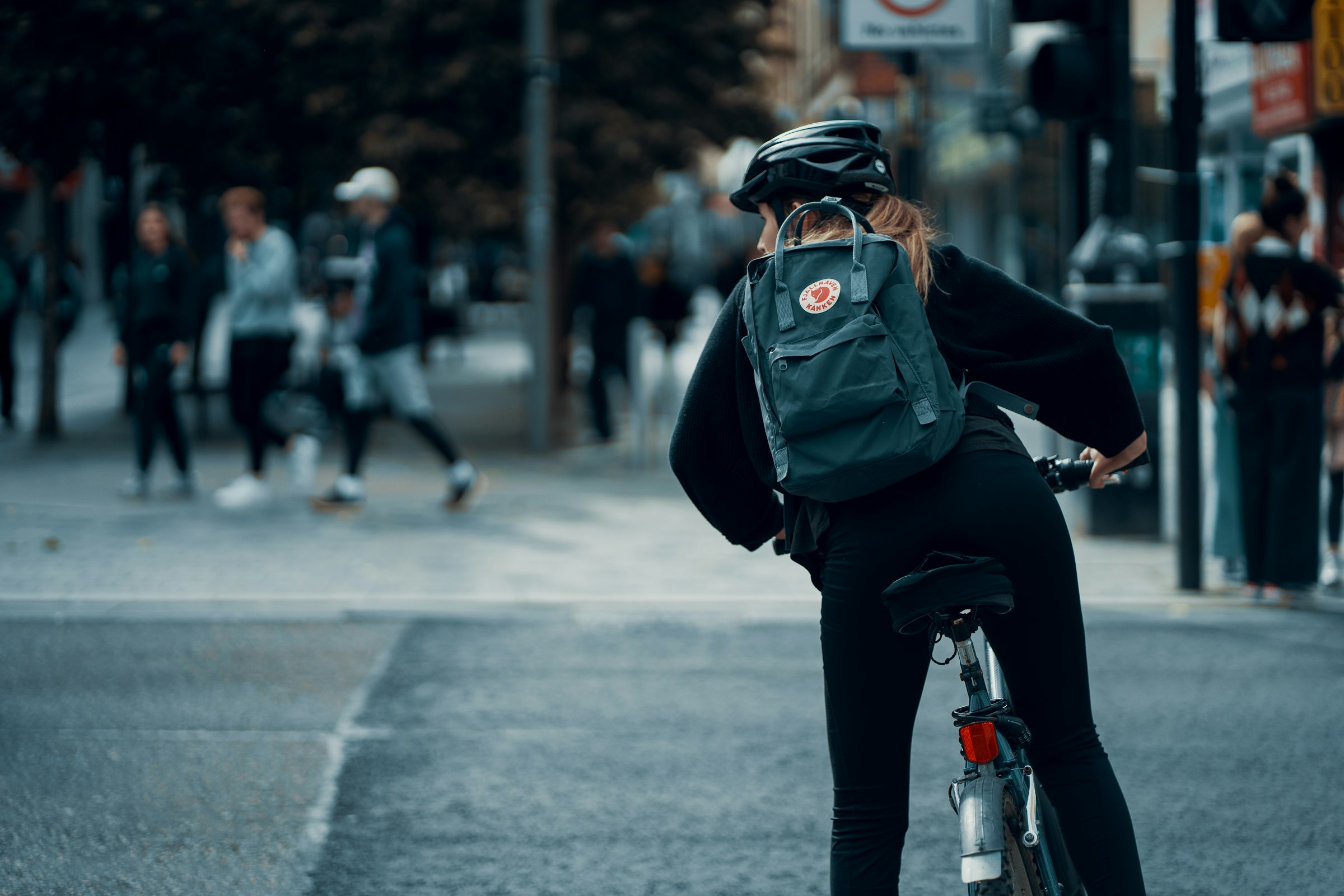 Donna in bicicletta con casco durante gli spostamenti quotidiani in città