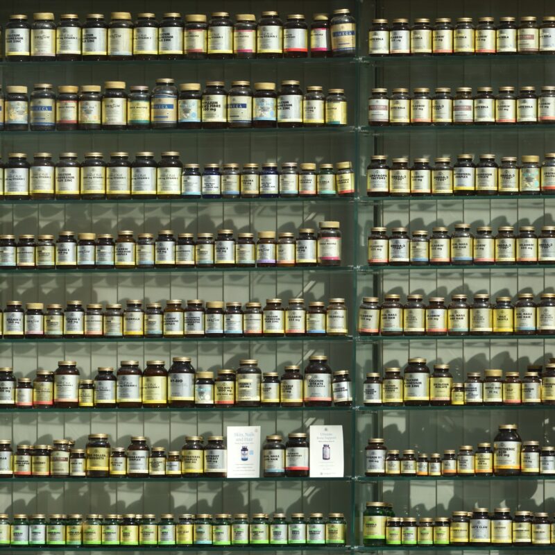 Diversi flaconi di integratori allineati su uno scaffale