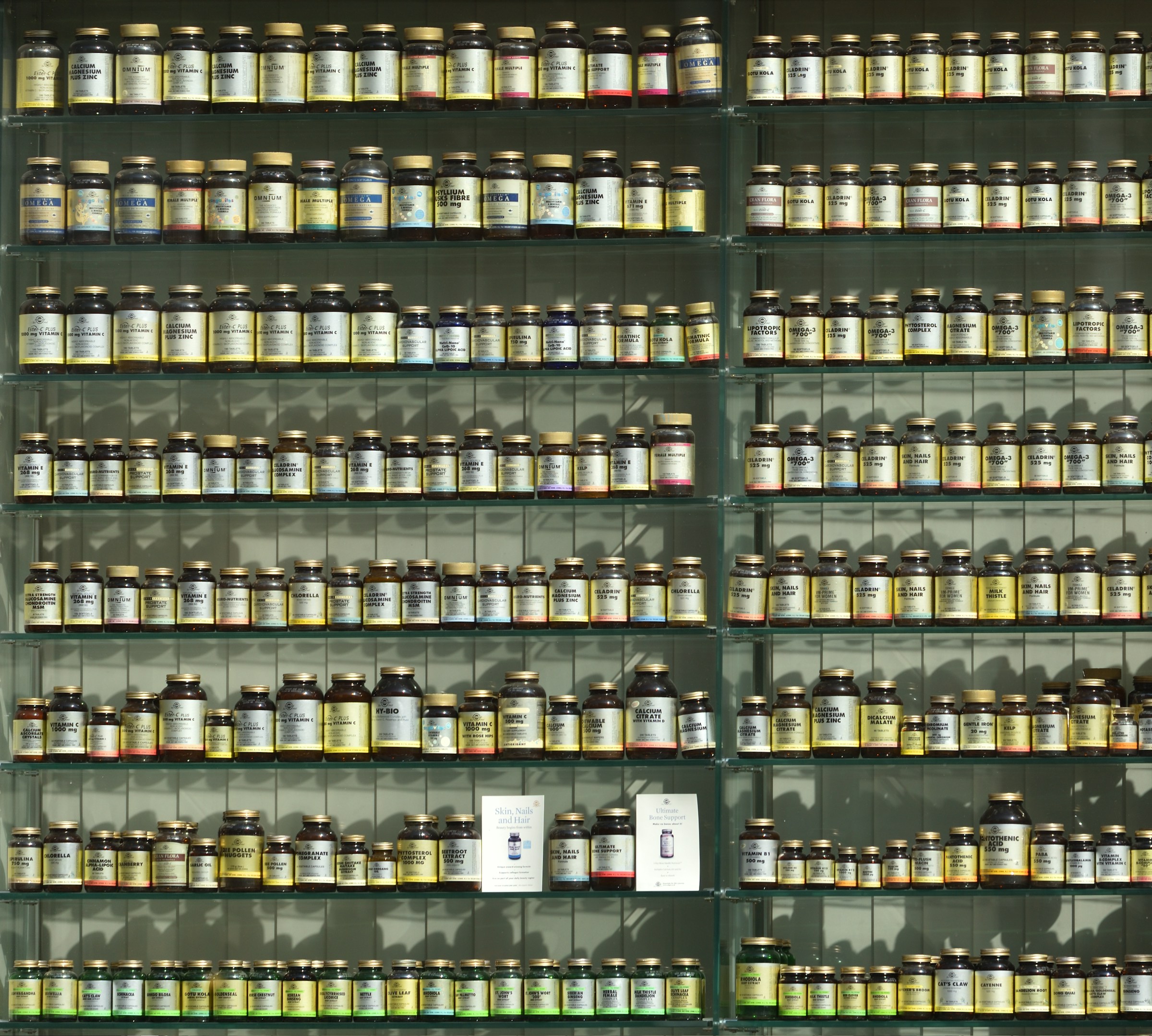 Diversi flaconi di integratori allineati su uno scaffale