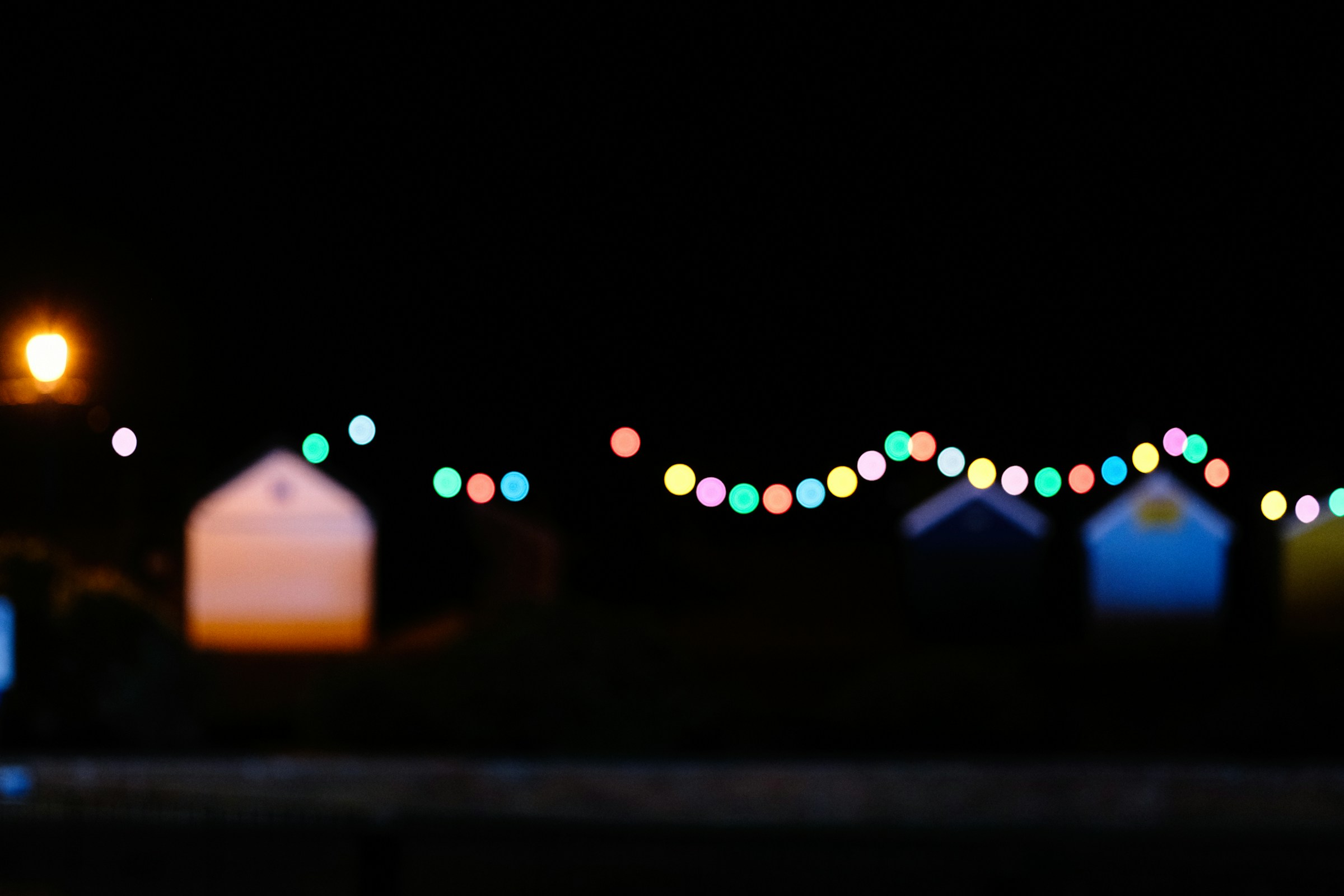 Luci decorative sospese sopra le vie di un paese durante una sagra estiva serale