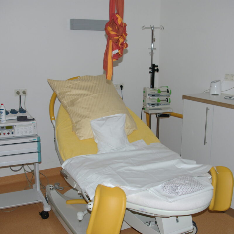 Sala parto ospedaliera con lettino e attrezzature per il travaglio