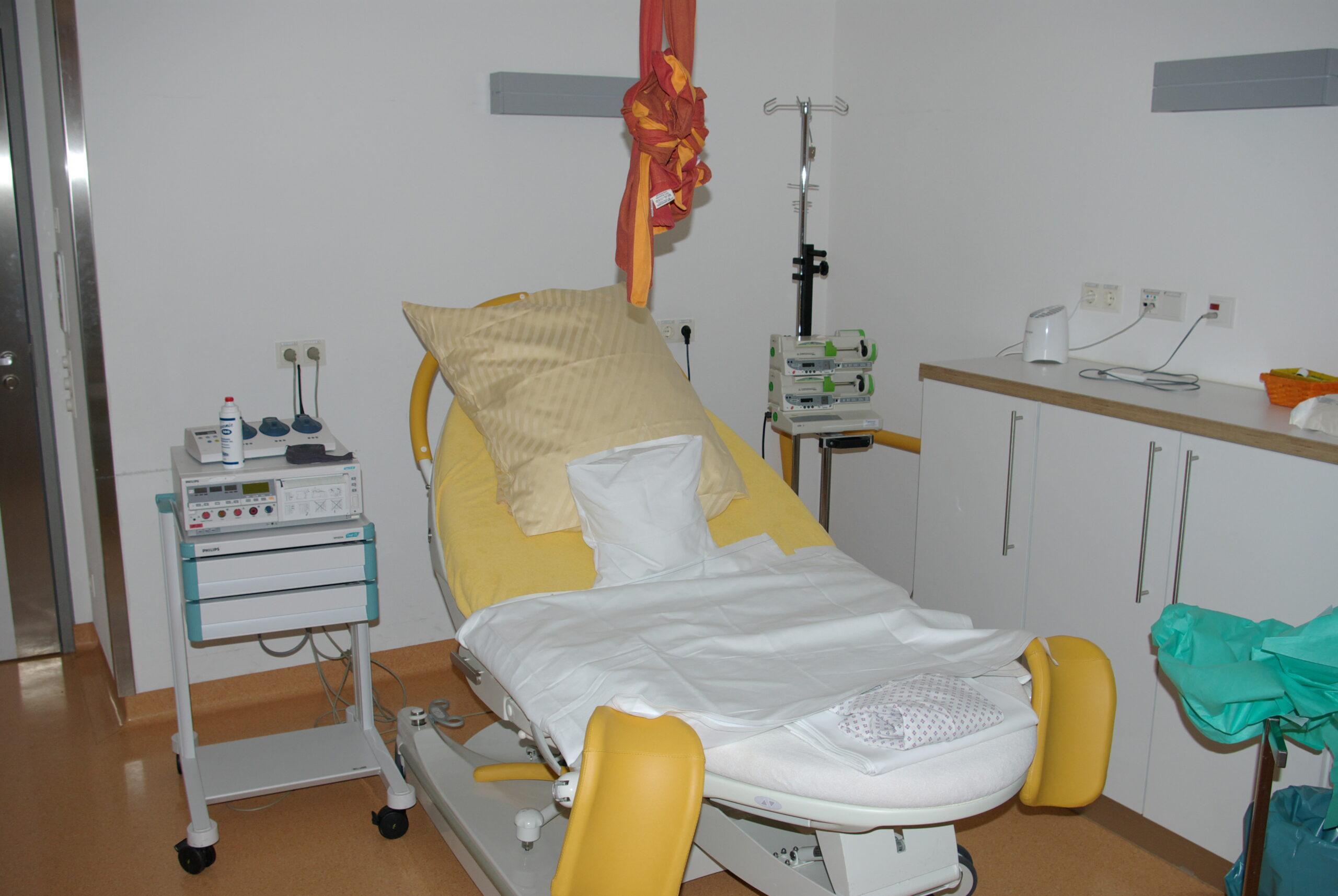 Sala parto ospedaliera con lettino e attrezzature per il travaglio