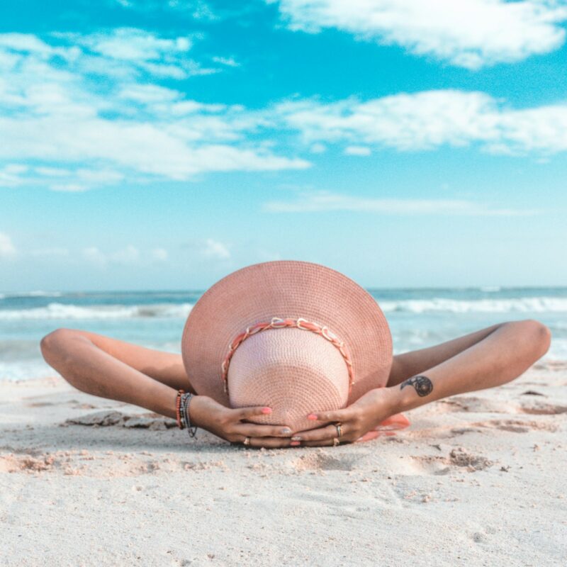 Donna al sole in spiaggia, esposizione solare e rischio di scottatura